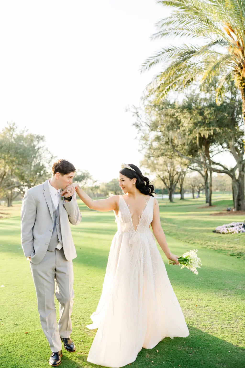Bride and Groom Walking on Golf Course Wedding Portrait | White Plunging Deep V Neckline A-Line Tulle and Sequin Eisen Stein Wedding Dress Ideas