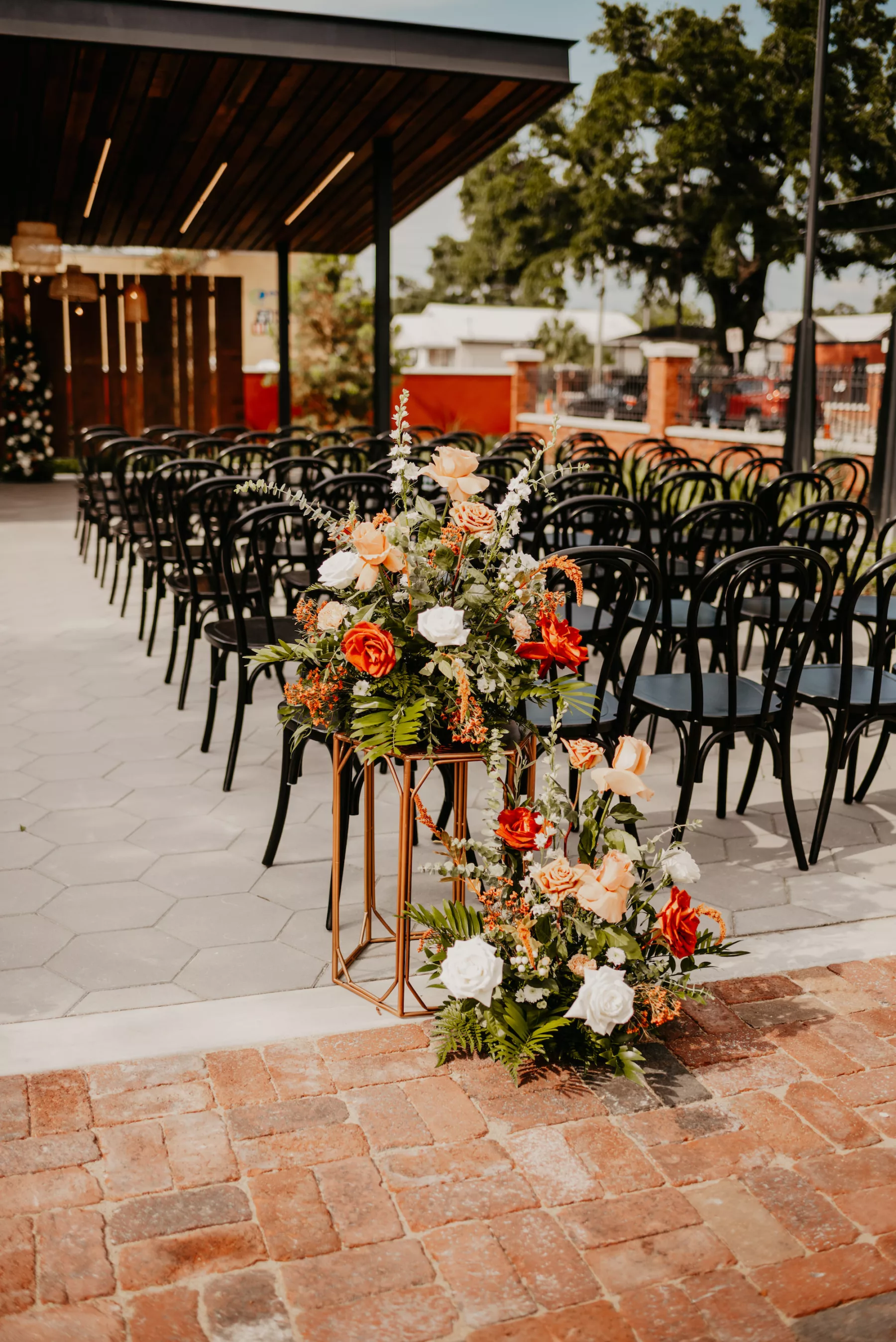 Terracotta, White, and Orange Roses, Greenery, Carnations, Snapdragon, and Greenery Aisle Decor for Outdoor Industrial Boho Wedding Ceremony Ideas | Tampa Courtyard Venue J.C. Newman Cigar Co.