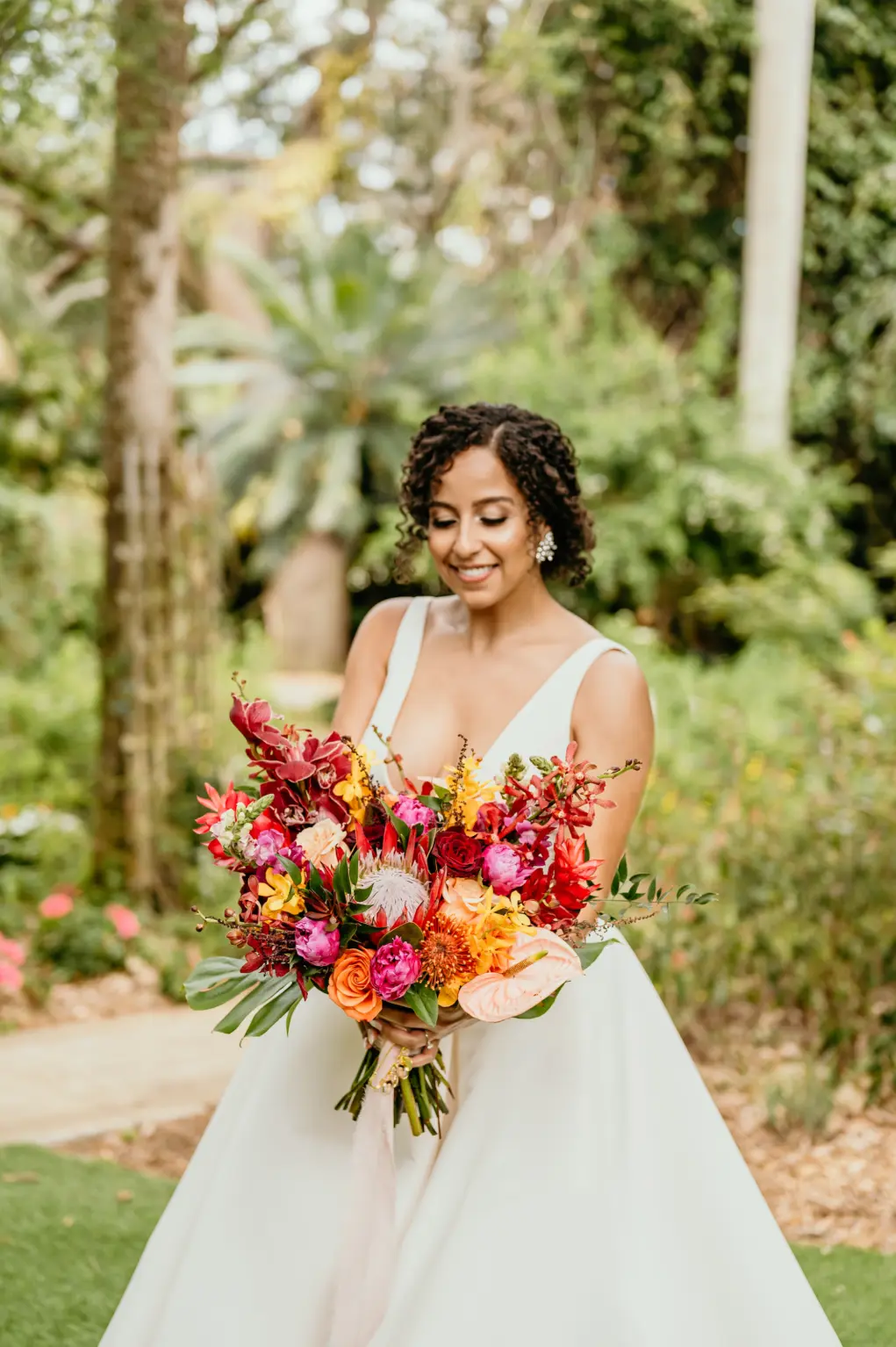 Tropical Bridal Bouquet with Red King Protea, Orange Pincushion Protea, Pink Roses, Orchids, and Palm Leaves | St Pete Florist Save The Date Florida