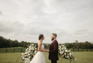 Romantic Outdoor Wedding Ceremony Vow Exchange Inspiration | Groom's Maroon Suit Ideas | Tampa Bay Event Venue La Hacienda at Snow Hill