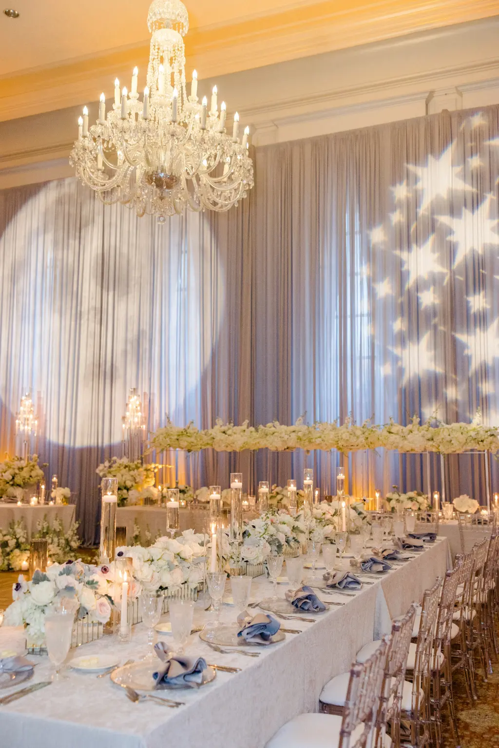 Whimsical White Wedding Reception Inspiration | Long Feasting Tables with Floating Candles, and Rose Table Top Flower Arrangement Ideas | Tampa Bay Lighting and DJ Grant Hemond & Associates
