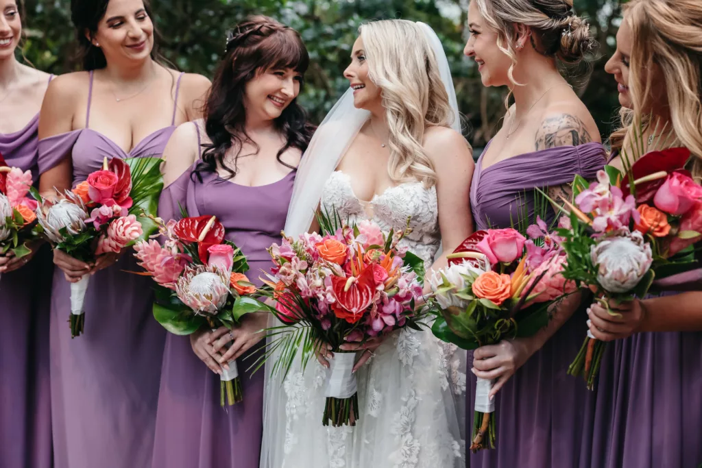 Mismatched Lavender Bridesmaids Dresses | Tropical Summer Wedding Bouquet with Orange Roses, Birds of Paradise, Red Anthurium, Pink Bougainvillea, and Palm Leaf Greenery | Tampa Bay Florist Save The Date Florida