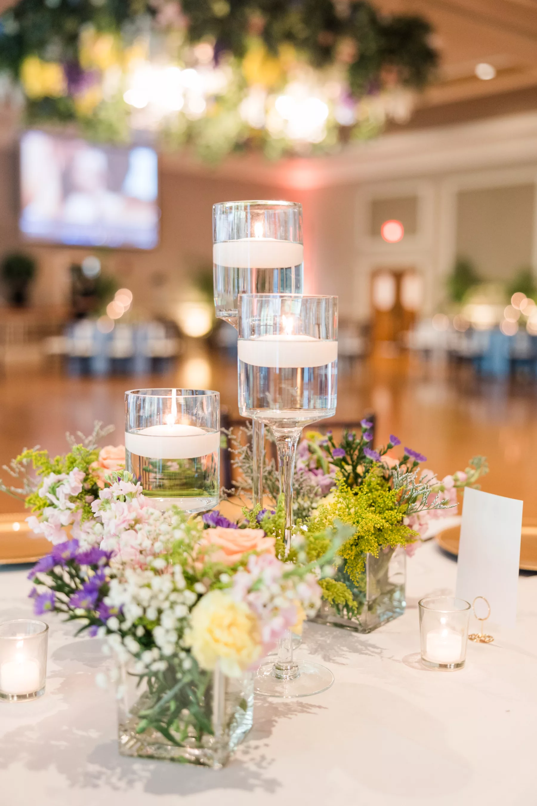 English Garden Inspired Ballroom Wedding Centerpiece Decor Ideas| Floating Candles with Purple Flowers and Baby's Breath in Glass Vase