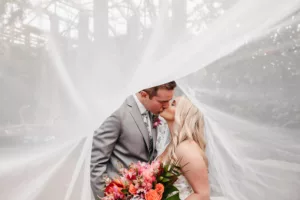 Romantic Bride and Groom Veil Wedding Portrait | Tropical Summer Bridal Bouquet with Orange Roses, Birds of Paradise, Bougainvillea, Mini Pineapples, Palm Leaves, and Greenery | Tampa Bay Florist Save The Date Florida | Photographer Lifelong Photography Studio
