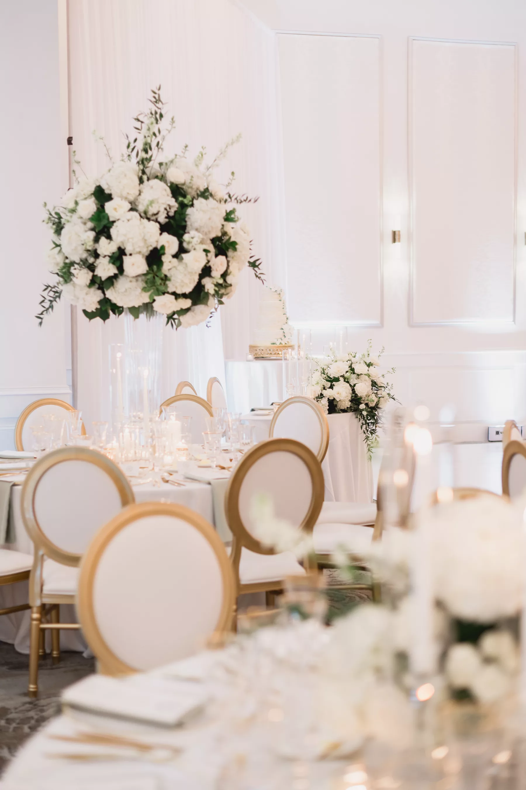 Elegant White and Gold Ballroom Spring Wedding Reception Decor Ideas | White Hydrangeas, Roses, and Greenery with Tall Glass Vase Centerpiece Inspiration | Tampa Bay Florist Bruce Wayne Florals | Clearwater Beach Kate Ryan Event Rentals