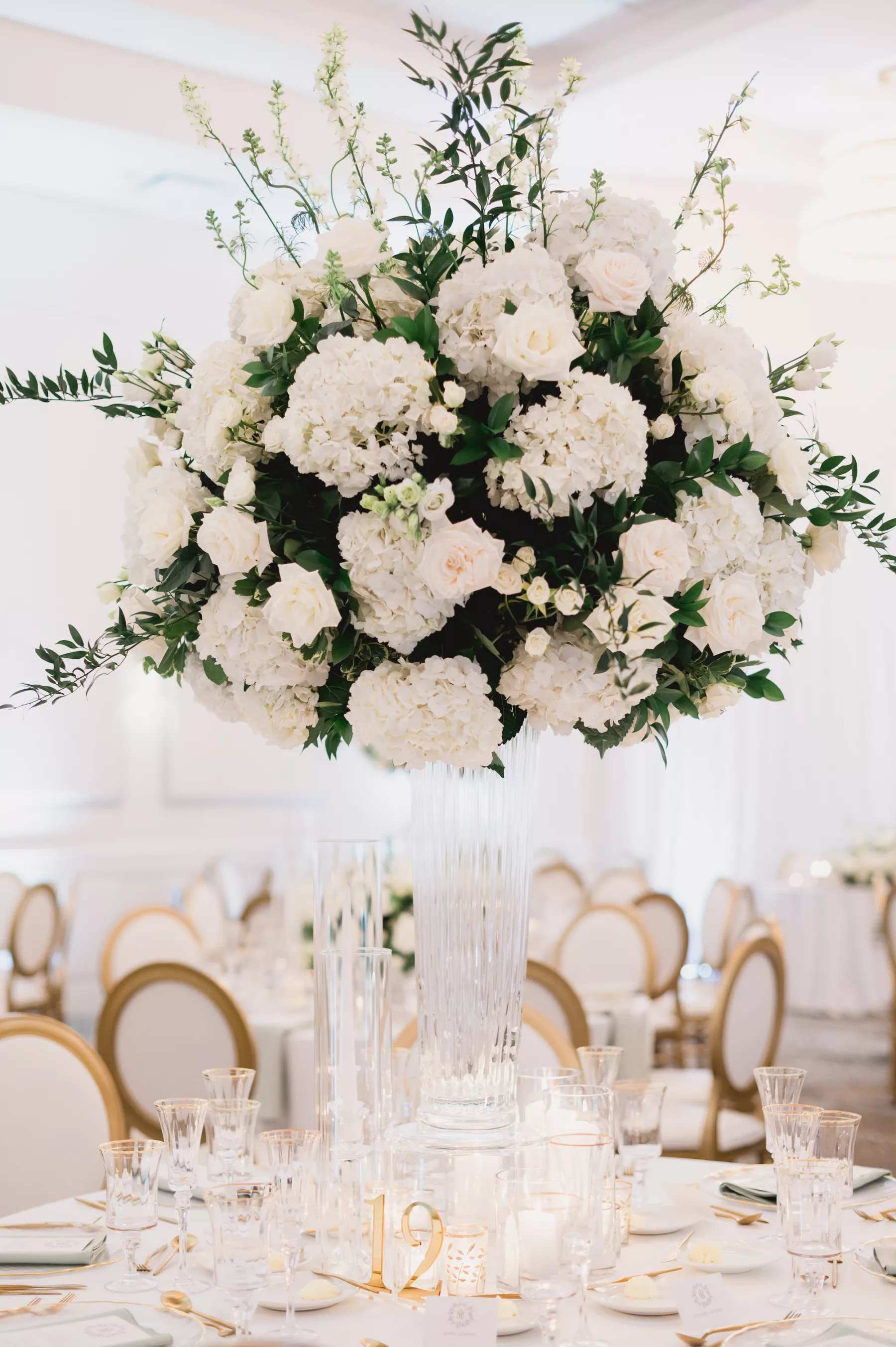 Elegant Spring White and Gold Ballroom Wedding Centerpiece Decor Ideas | White Hydrangeas, Roses, and Greenery with Tall Glass Vase | Tampa Bay Florist Bruce Wayne Florals