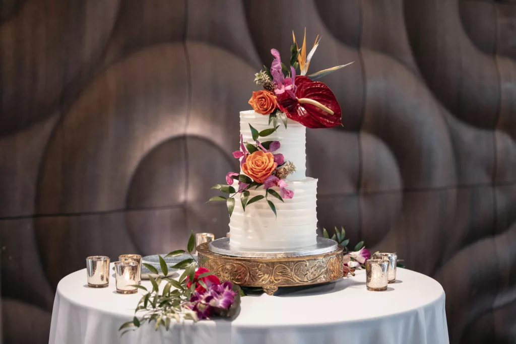 Two-Tiered Round Wedding Cake with Textured Buttercream and Tropical Summer Orange Roses, Pink Bougainvillea, Red Anthurium, and Greenery Flower Accents | Tampa Bay Florist Save The Date Florida