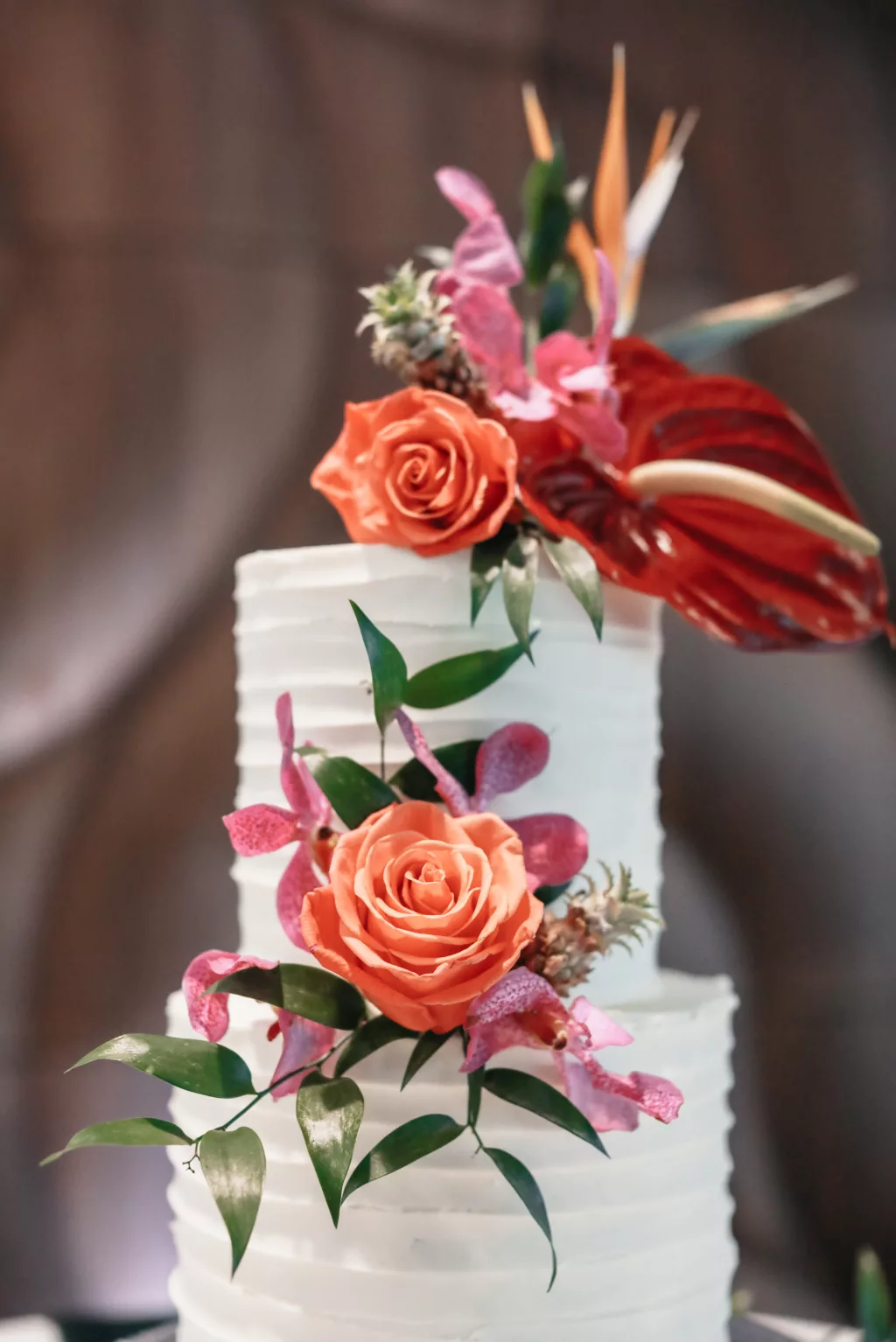 Two-Tiered Round Wedding Cake with Textured Buttercream and Tropical Summer Orange Roses, Pink Bougainvillea, and Anthurium Flower Accents | Tampa Bay Florist Save The Date Florida