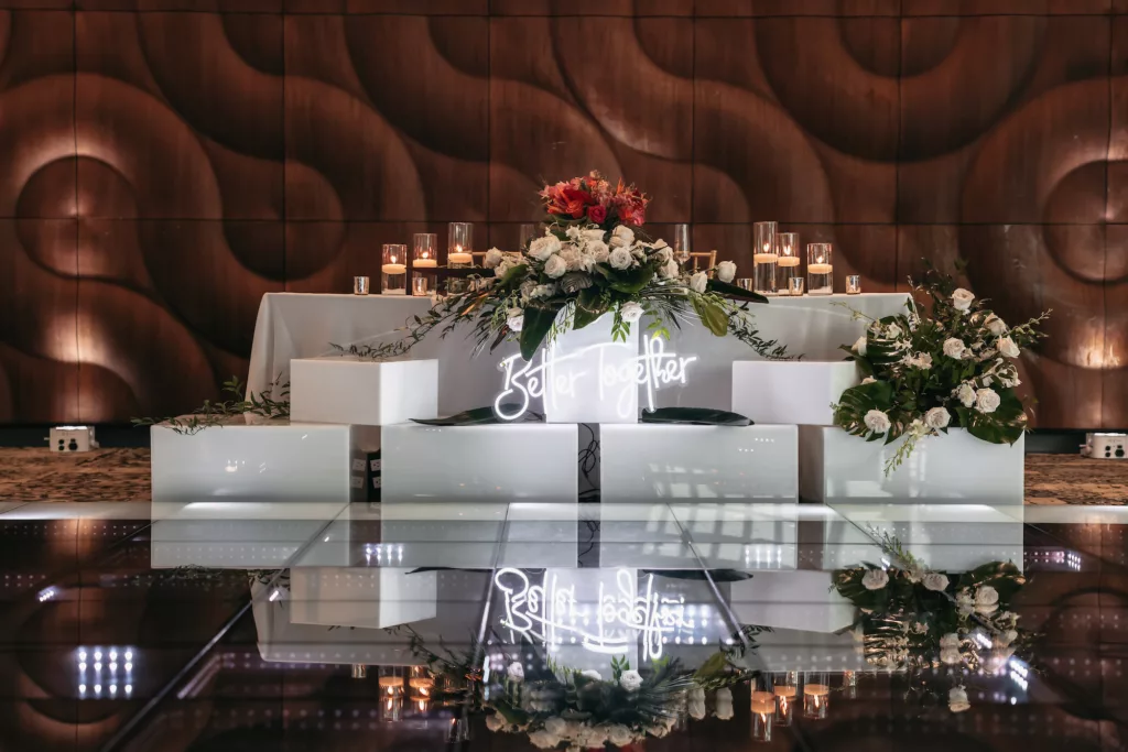 White Modern Wedding Reception Sweetheart Head Table with Better Together Neon Sign, Floating Candles, and White Roses with Tropical Greenery Decor Ideas | Tampa Bay Florist Save The Date Florida | Venue Florida Aquarium