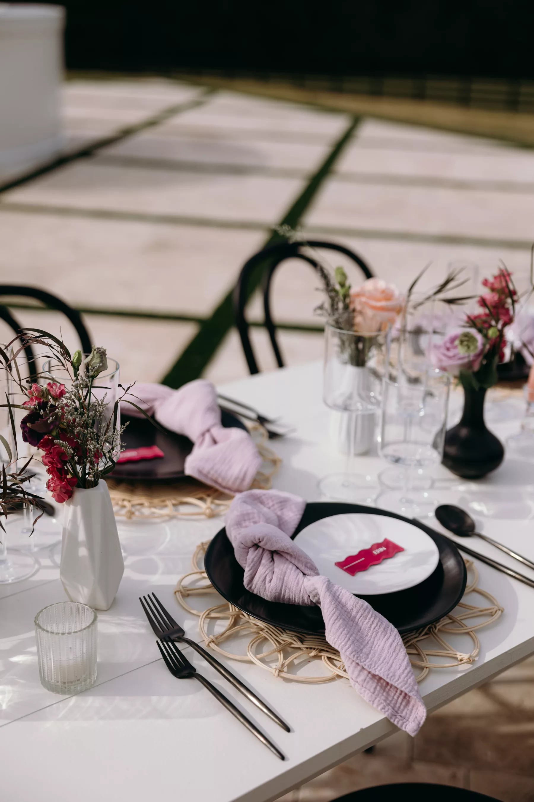 Moody Modern Wedding Reception Tablescape Decor Ideas | Black Plate and Flatware, Purple Linen Napkins, and Rattan Place Mat