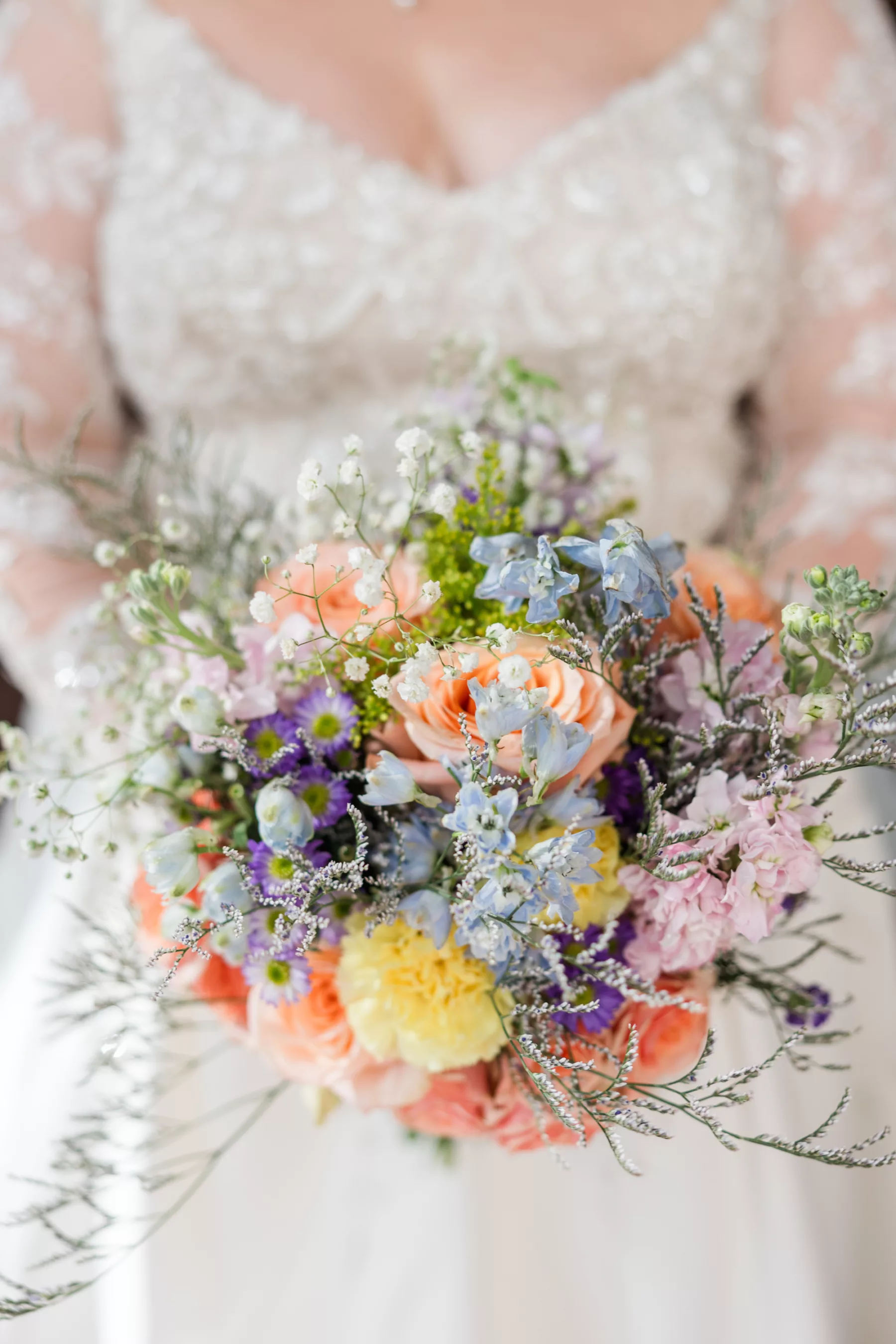 Whimsical Colorful Spring Wedding Bouquet Ideas | Peach Roses, Yellow Carnations, Blue Stock Flowers, and Greenery Floral Arrangement |