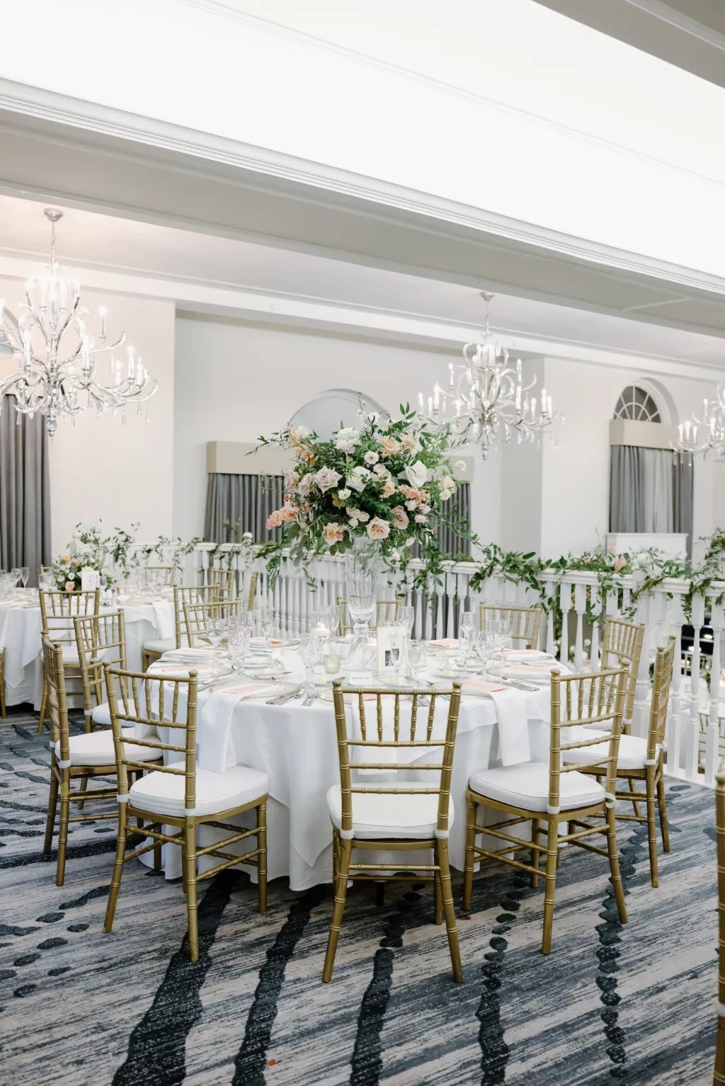 White and Gold Grand Ballroom Wedding Reception Ideas | Gold Chiavari Chair | Tall Flower Stand with White and Pink Roses, and Greenery Centerpiece Decor Inspiration