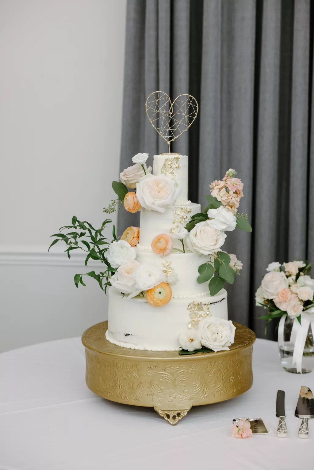 Four-Tiered White Round Buttercream Wedding Cake with Orange Anemone, White Roses, and Greenery Accents