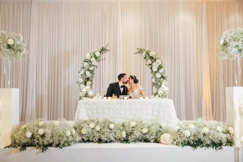 Extravagant White Modern Sweetheart Table with White Baby's Breath, Chrysanthemums, and Greenery Backdrop and Floor Arrangement Wedding Reception Decor Ideas | Tampa Bay Event Venue Hilton Tampa Downtown | Planner Special Moments Event Planning | Photographer Lifelong Photography Studio