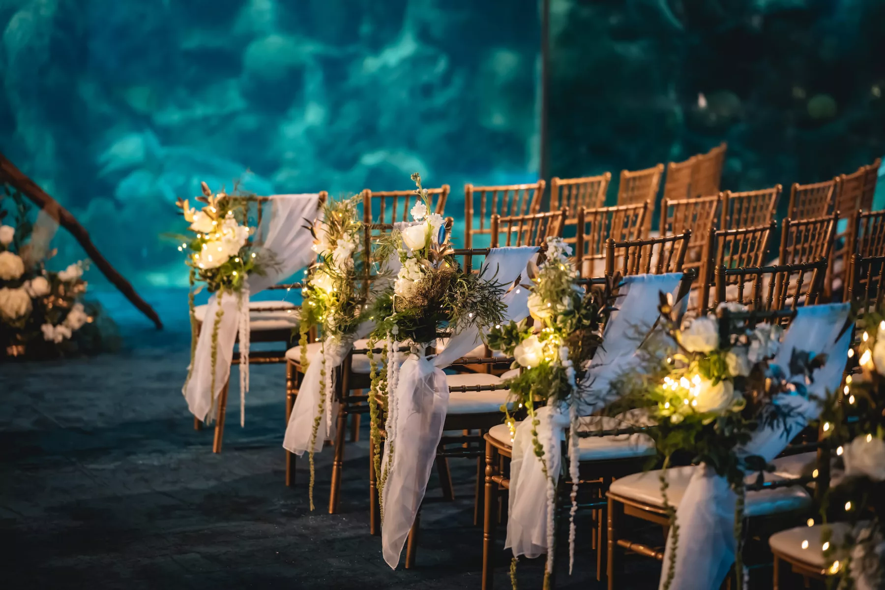 Elegant Gold Chiavari Chairs with White Drapery, Wisteria, Roses, and Fairy Light Wedding Ceremony Aisle Decor Inspiration | Tampa Bay Florist Lemon Drops | Outside The Box Event Rentals