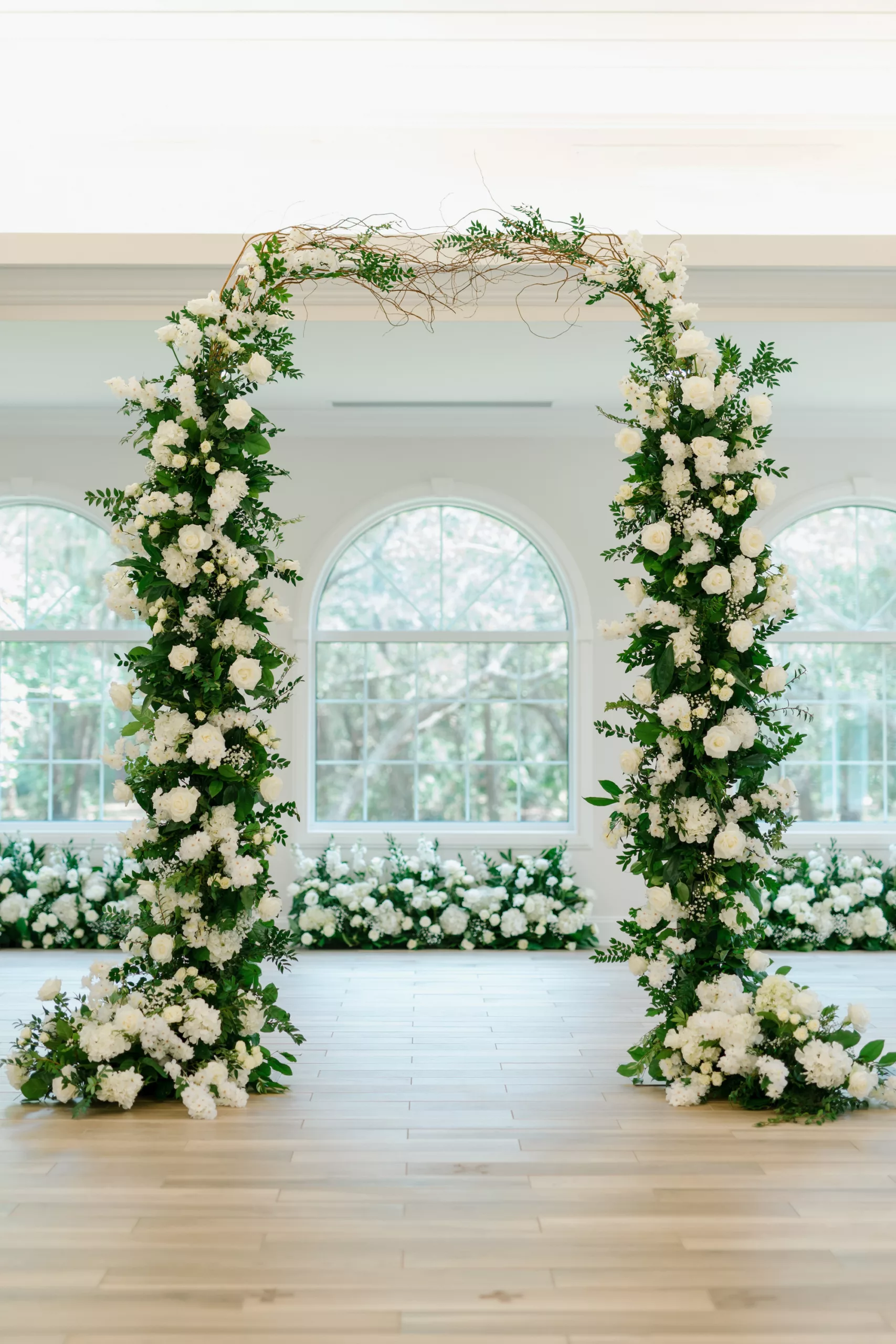 Elegant White Roses, Hydrangeas, Baby's Breath, and Greenery Spring Wedding Ceremony Arch Display Ideas