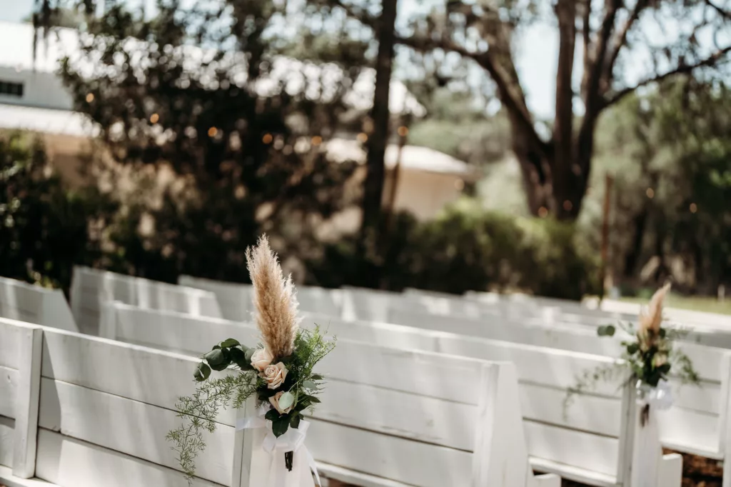 Pampas Grass, Roses, and Greenery Spring Wedding Ceremony Aisle Decor Ideas | White Wood Pews Outdoor Ceremony