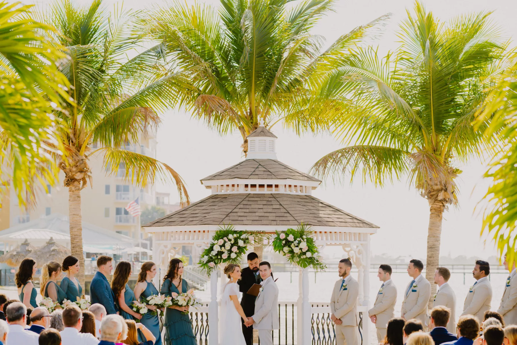 Bride and Groom Vow Exchange Tropical Beach Wedding Ceremony Inspiration | Pink and White Roses, Monstera, Palm Leaf Gazebo Spring Decor Ideas | Tampa Bay Florist Monarch Events and Design | Waterfront St Pete Venue Isla Del Sol Yacht and Country Club