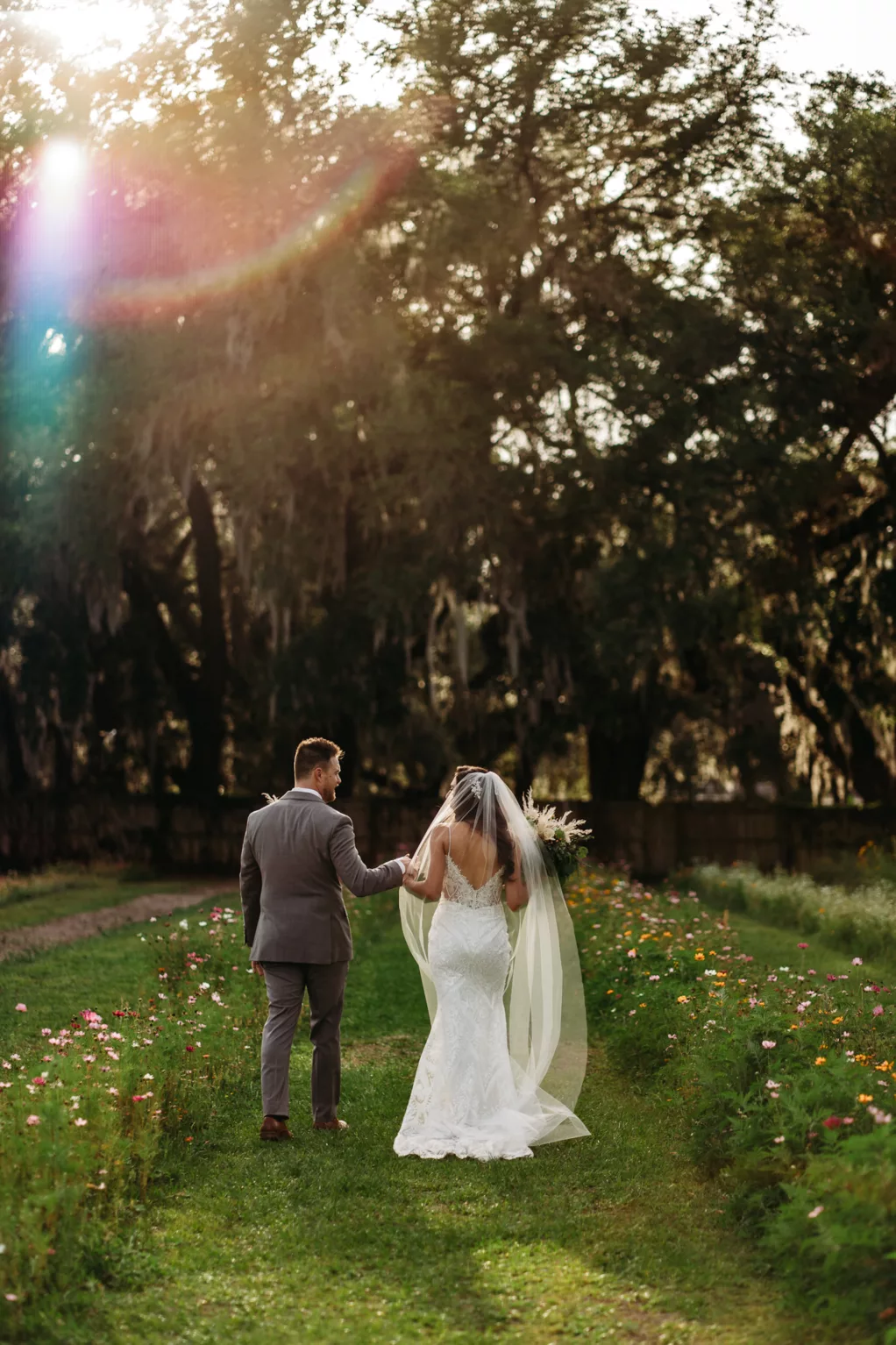 Bride and Groom Walking Through Wildflower Garden Wedding Portrait | Tampa Bay Photographer Sabrina Autumn Photography
