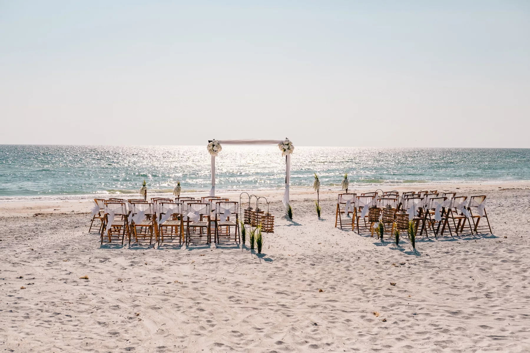intimate Bradenton Beach Wedding Decor Inspiration | Bamboo Rattan Chairs and Aisle Lantern Ideas | Planner Gulf Beach Weddings