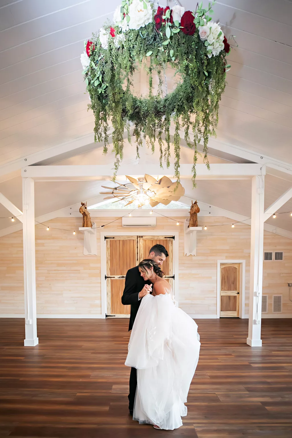 Bride and Groom First Dance | Indoor Modern Barn Reception with Floral Greenery Suspended Chandelier | Brooksville Event Venue Legacy Lane Weddings | Photographer Limelight Photography