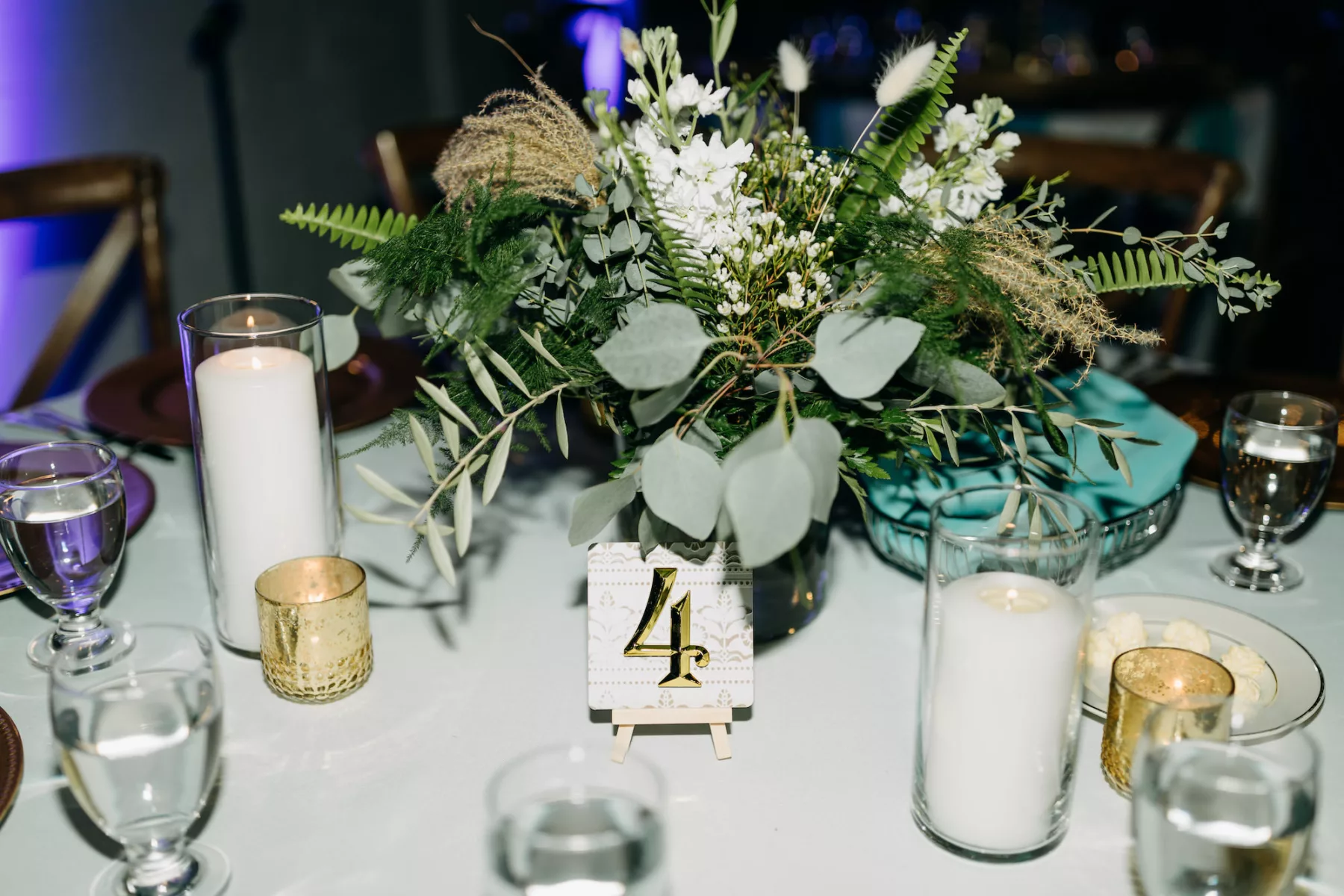 Boho Wedding Reception Centerpiece Ideas | Candles, Gold Votives, and Table Numbers | White Flowers, Fern, and Greenery Floral Arrangement Inspiration