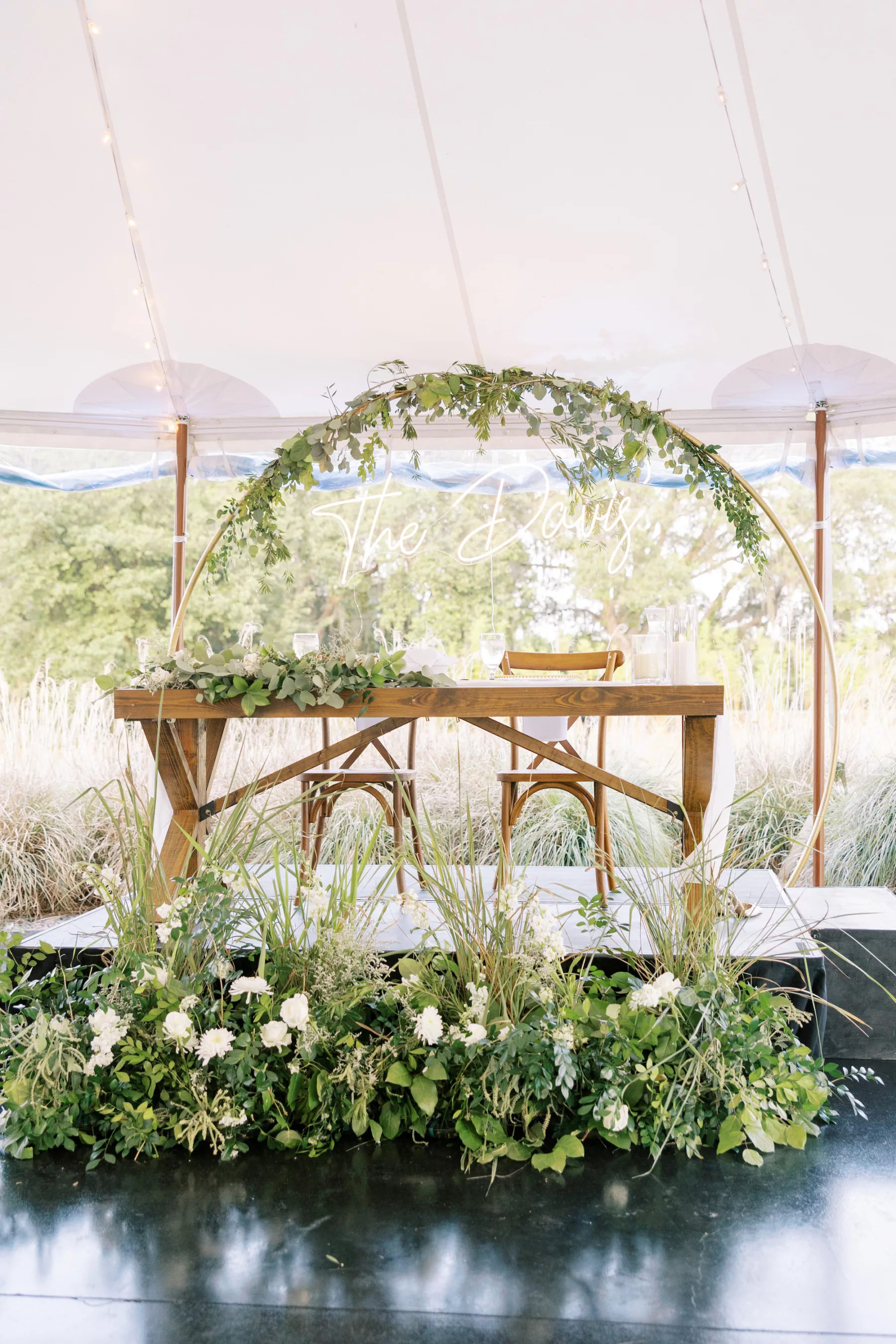 Whimsical Garden Wedding Reception Sweetheart Table Decor Inspiration | Gold Hoop Backdrop with Neon Sign | White Snapdragons and Greenery Floor Arrangement Ideas