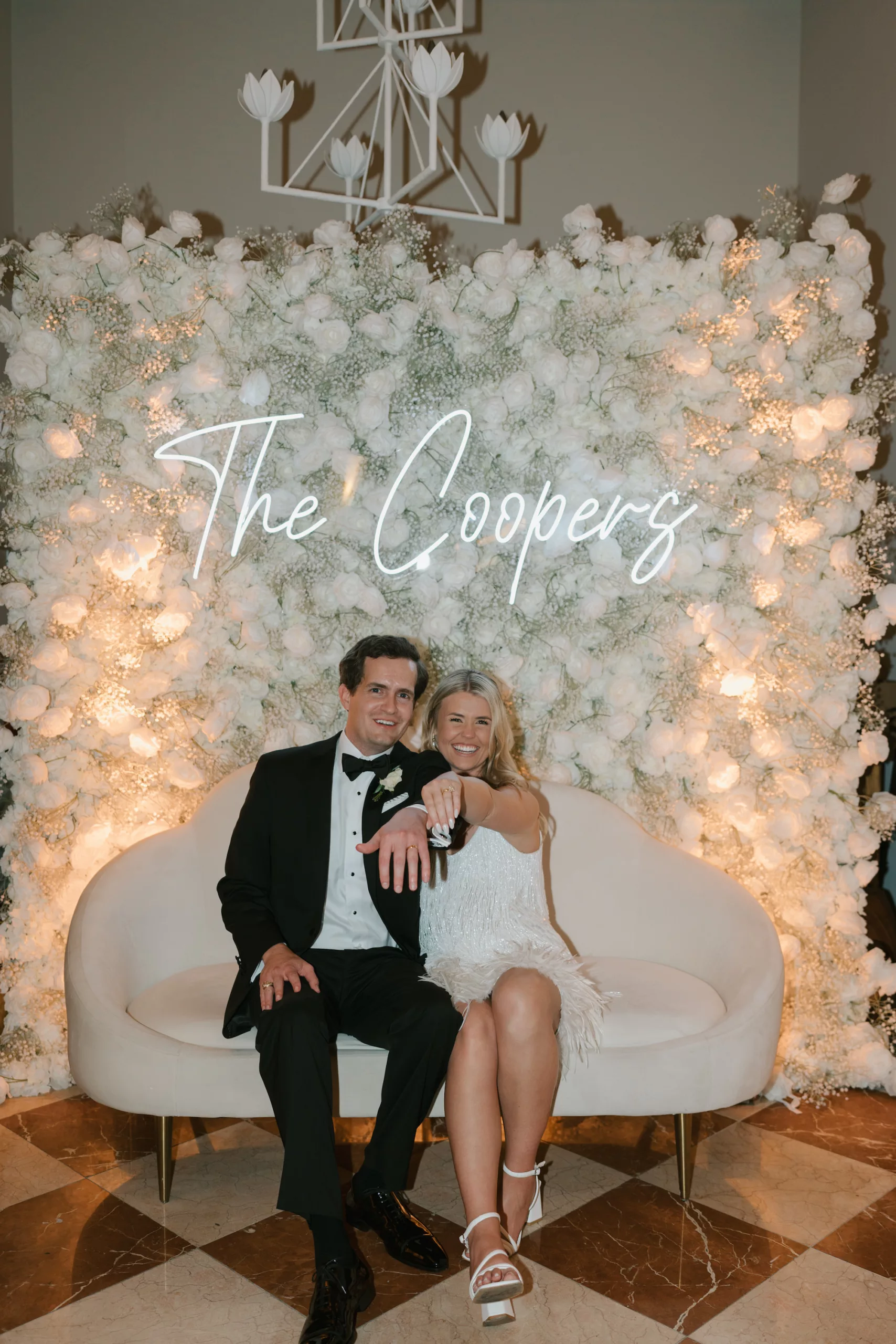 Classic Wedding Reception Decor Ideas | Custom Neon Sign with White Rose and Baby's Breath Flower Wall Backdrop | White Love Seat Inspiration