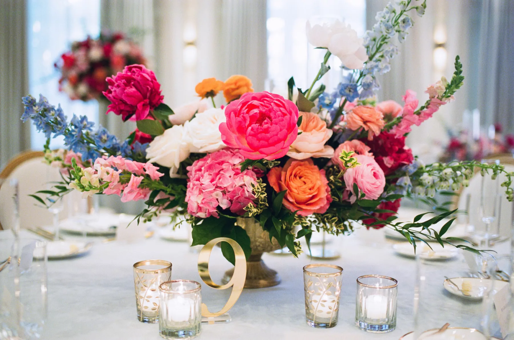 Luxurious Pink and Blue Wedding Reception Centerpiece Tablescape Decor Ideas | Pink Anemones and Hydrangeas, Orange Garden Roses, Blue Stock Flowers | Gold Acrylic Table Number Sign Inspiration | Tampa Bay Florist Bruce Wayne Florals