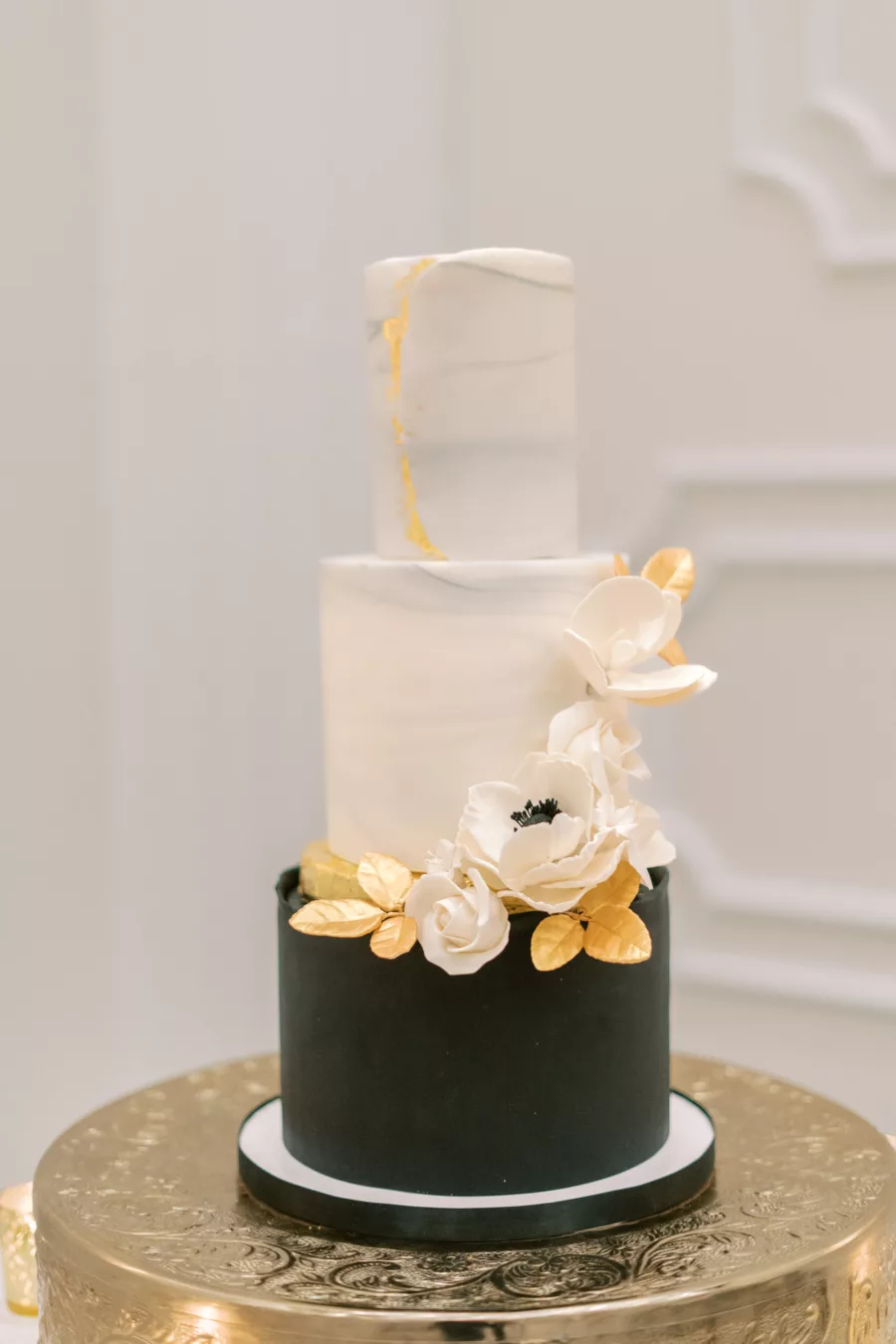 Round Three-Tiered Marble and Black Fondant Wedding Cake Inspiration with White Anemone and Gold Leaves Accents | Tampa Bay Cake Company