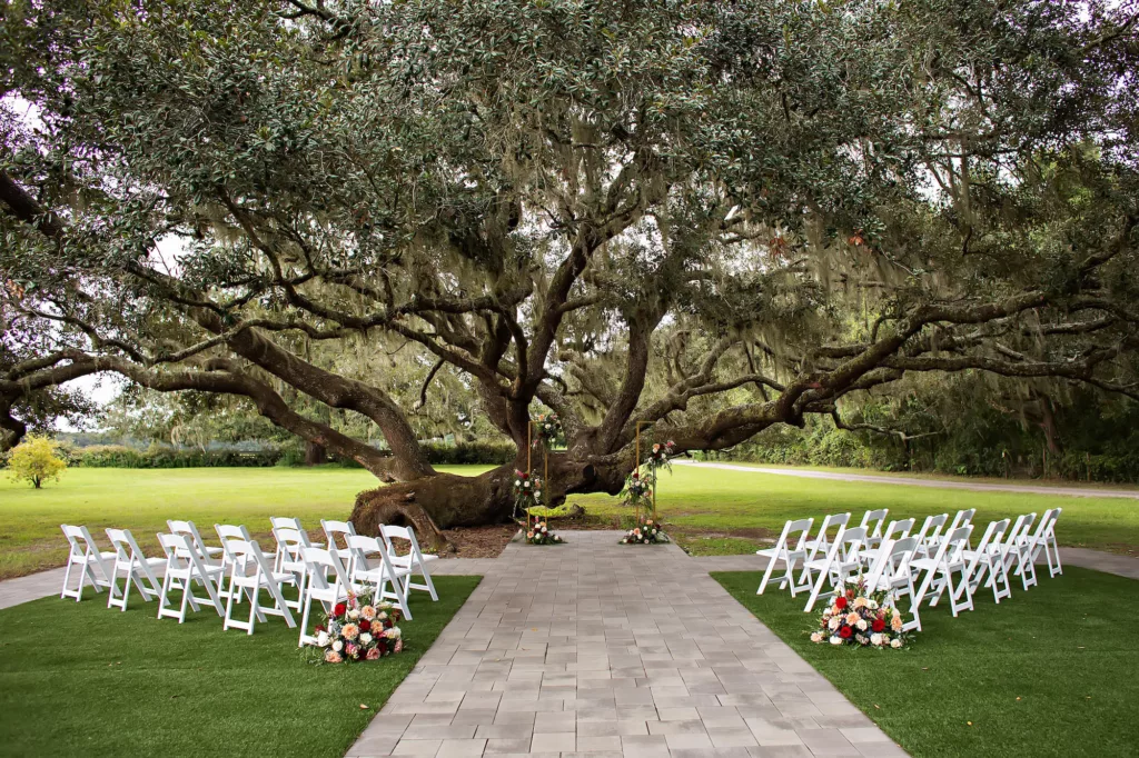 Elegant Outdoor Wedding Ceremony Tree Inspiration | Folding White Garden Chairs | Tampa Bay Event Venue Legacy Lane Weddings | Florist Save the Date Florida