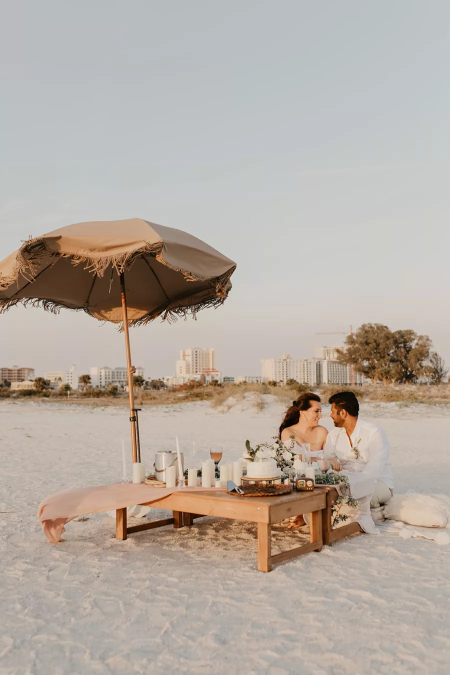 Intimate Bride and Groom Beach Wedding Elopement Decor Inspiration | Low Picnic Table, Boho Tassel Umbrella, and Flameless Candles