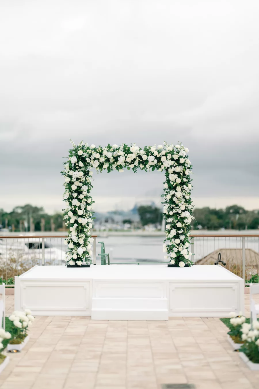 Timeless Outdoor Waterfront Winter Wedding Ceremony with White Rose and Greenery Arch and Stage Inspiration | St Pete Historic Hotel Venue The Vinoy