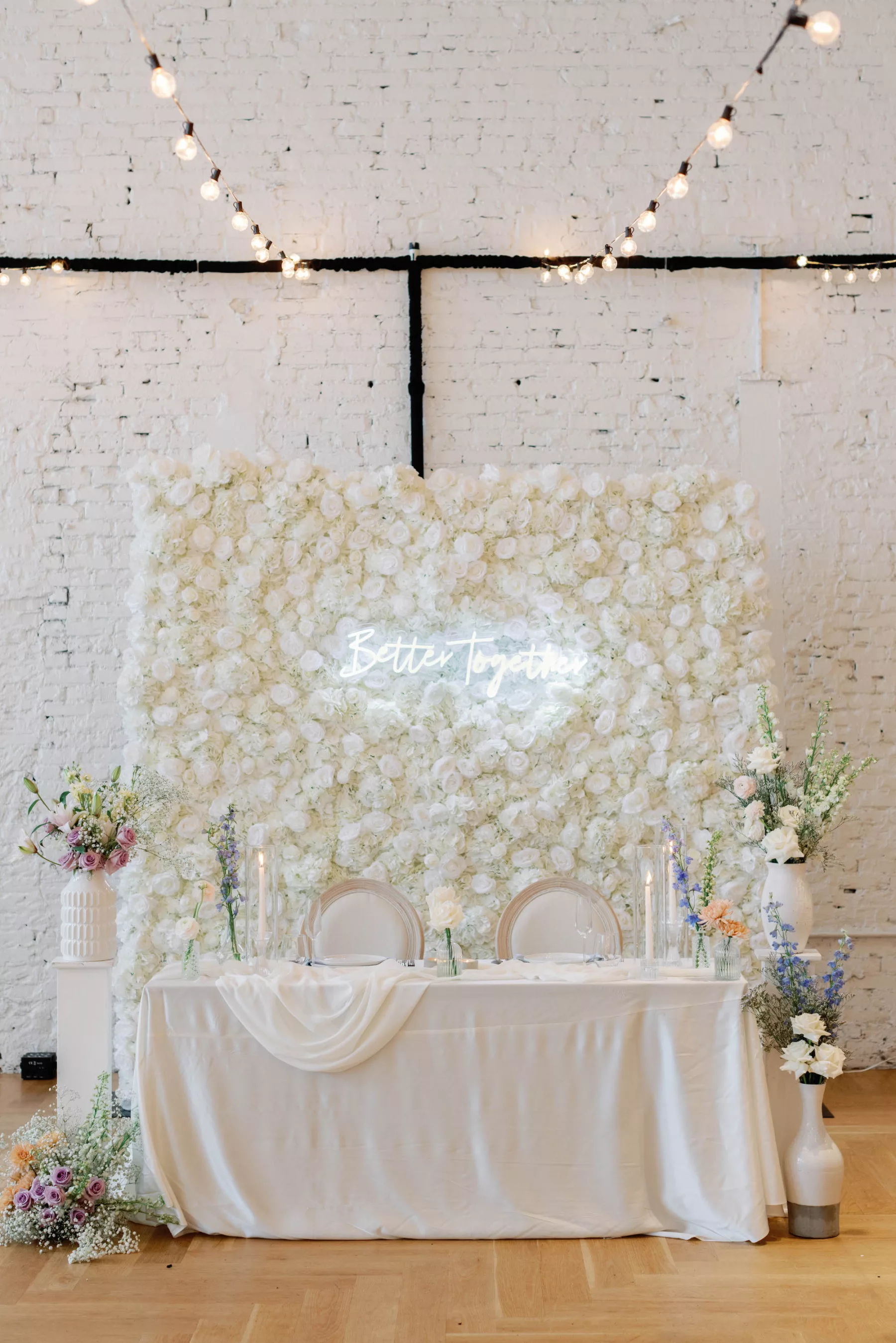 Whimsical Spring Wedding Reception Sweetheart Decor Ideas | White Rose Wall Backdrop Inspiration | Better Together Neon Sign | Blue and White Lily of the Valley, White Carnations, and Orange Chrysanthemums | Tampa Bay Event Planners Olive Tree Weddings | Event Venue Hotel Haya