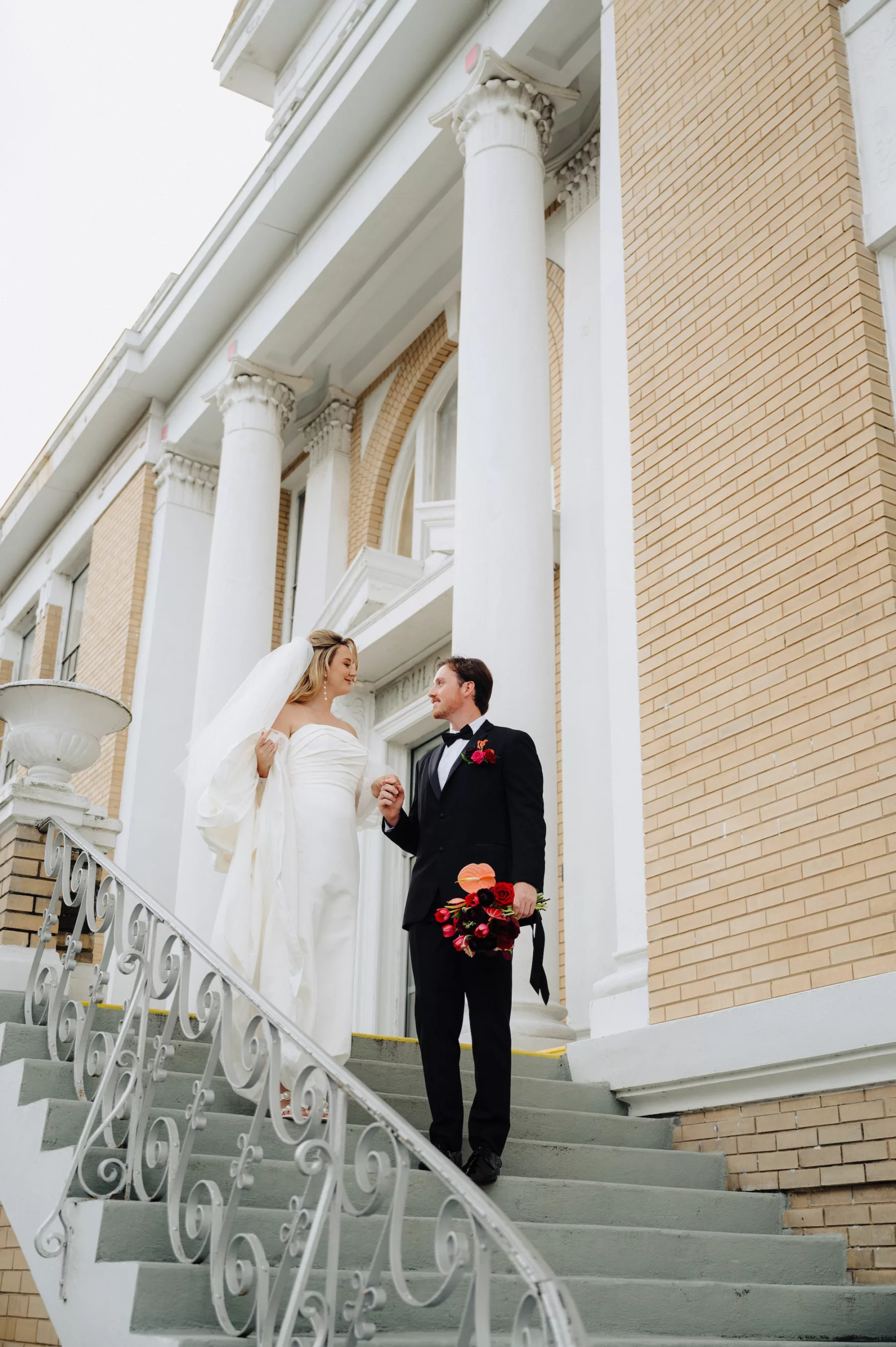 Bride and Groom Walking Down Stairs Wedding Portrait | Historic Ybor Event Venue Cuban Club | Tampa Bay Photographer McNeile Photography | Content Creator Behind The Vows