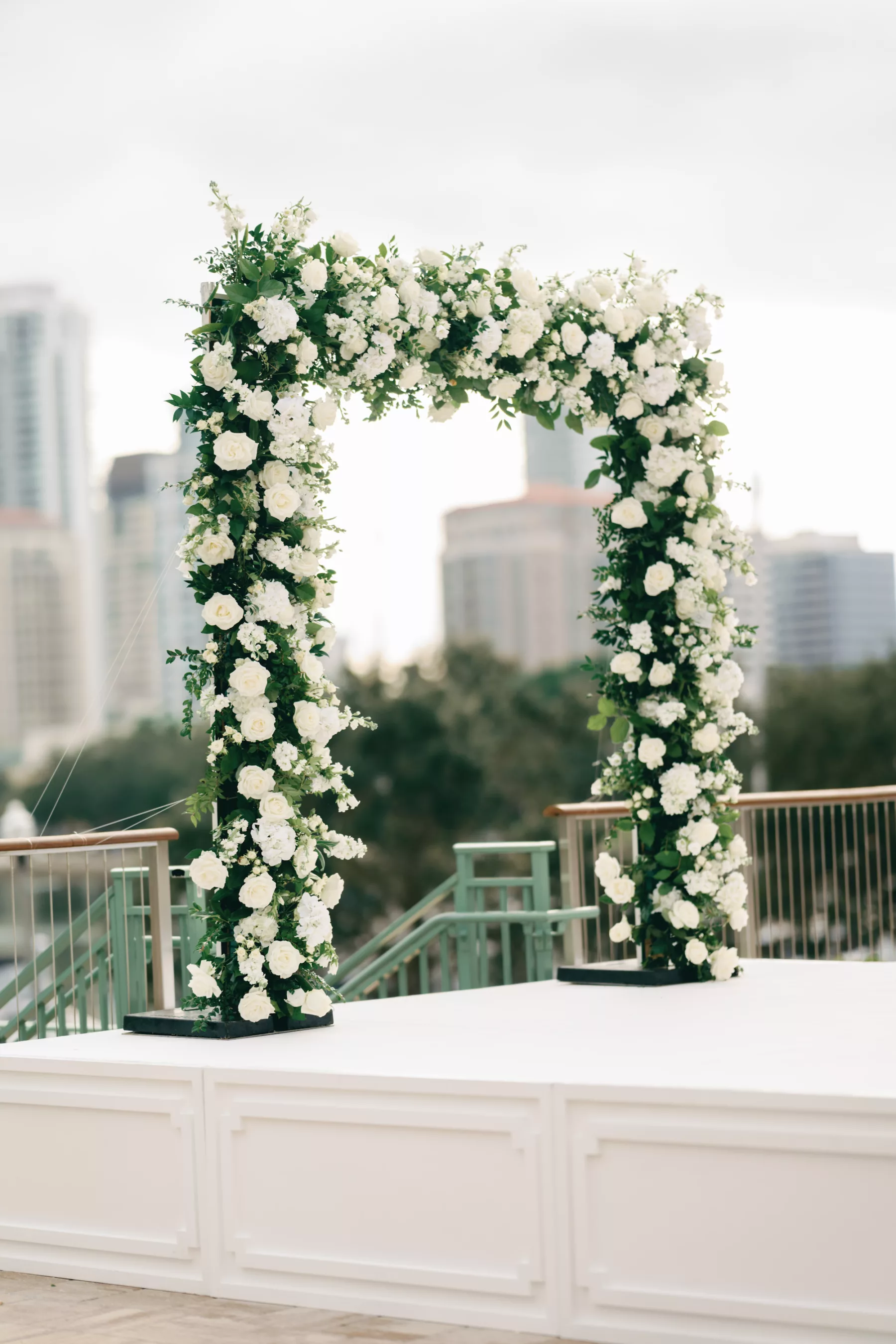 Timeless Outdoor Waterfront Winter Wedding Ceremony with White Rose and Greenery Arch and Stage Inspiration
