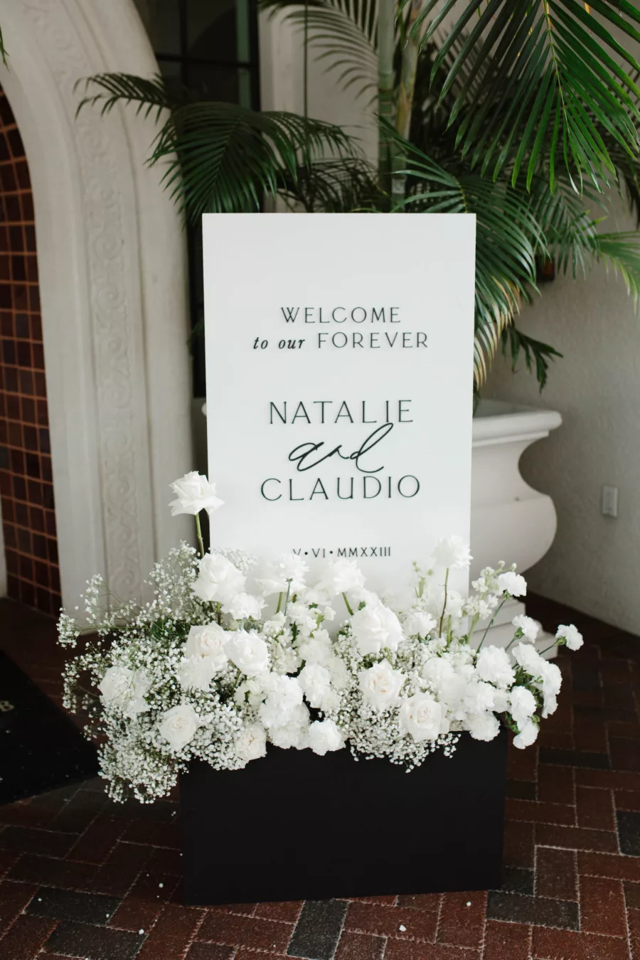 Modern White Welcome To Our Forever Ceremony Wedding Sign with Black Flower Box Inspiration | White Roses, Carnations, and Baby's Breath Floral Arrangement Ideas