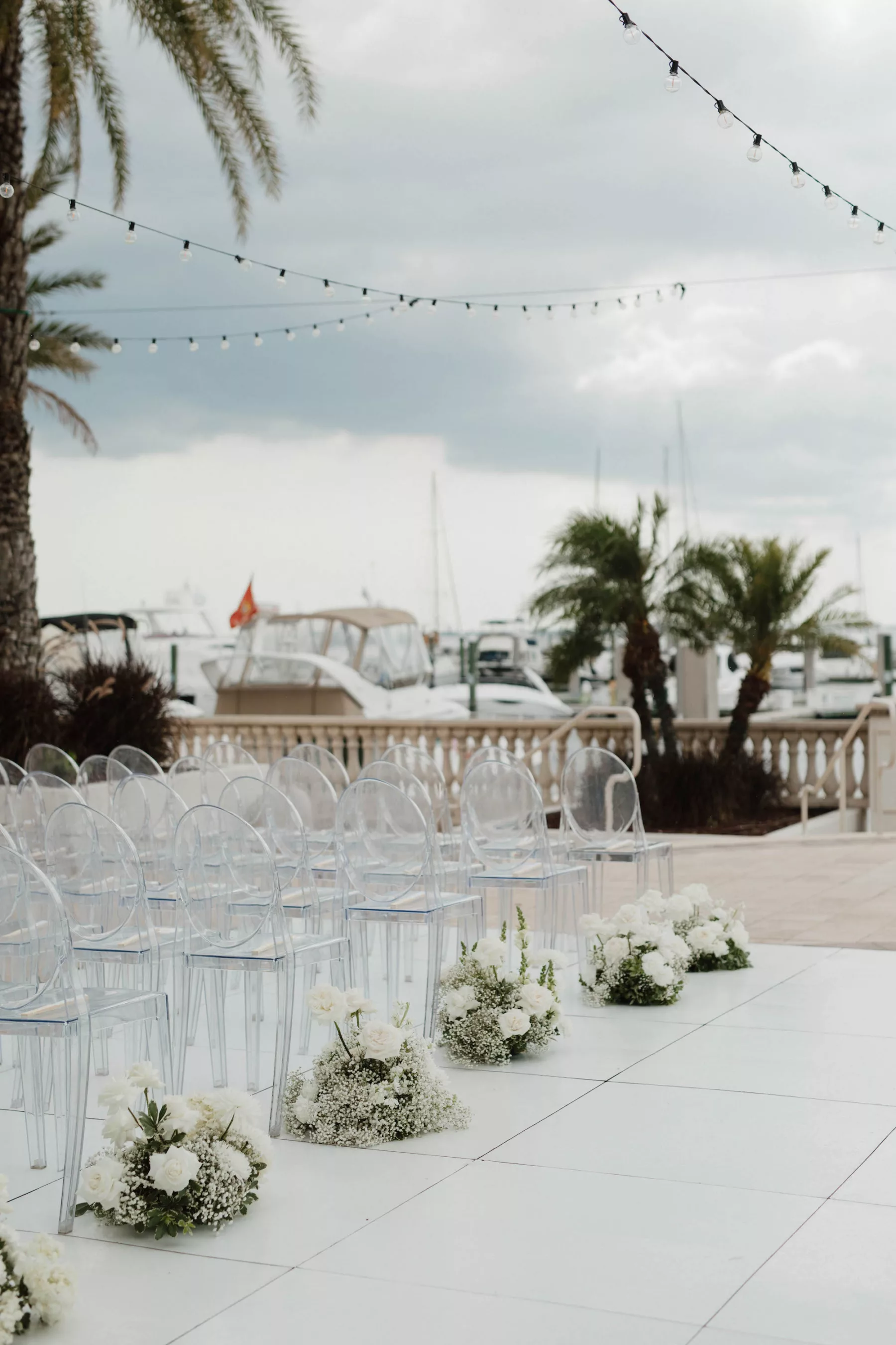 Timeless Monochromatic Outdoor Oceanview Wedding Ceremony Decor Inspiration | Acrylic Ghost Chairs | White Rose and Baby's Breath Aisle Flower Arrangement Ideas | Tampa Bay Event Venue Westshore Yacht Club | Kate Ryan Event Rentals