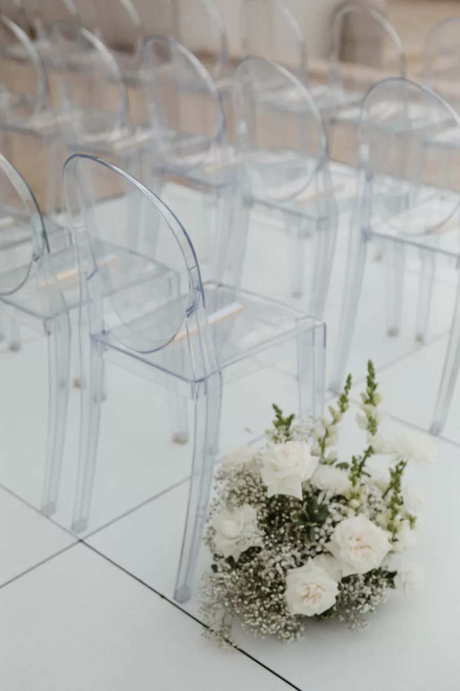 Acrylic Wedding Ceremony Ghost Chairs with White Roses, Baby's Breath, and Snap Dragon Aisle Floral Arrangement Decor Ideas | Tampa Bay Kate Ryan Event Rentals