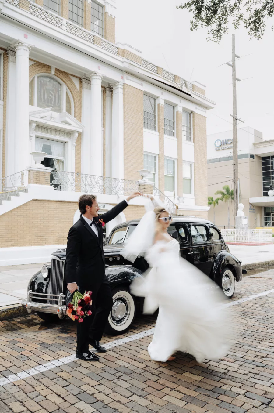Bride and Groom Dancing in the Road with Classic Wedding Day Getaway Car Inspiration | Tampa Bay Car Rental Classically Ever After | Photographer McNeile Photography | Planner EventFull Weddings | Content Creator Behind the Vows