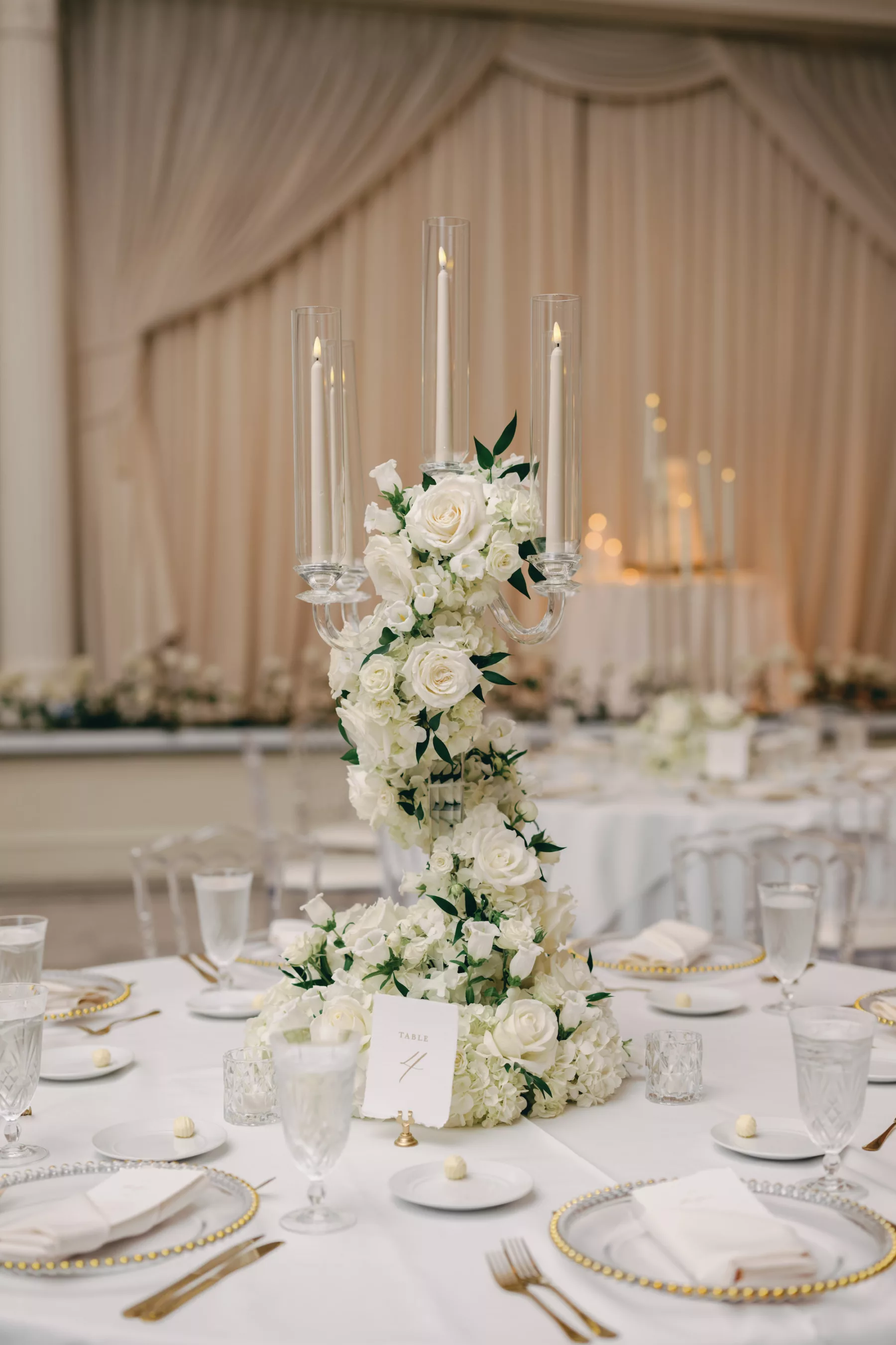 Timeless Monochromatic Wedding Reception Centerpiece Decor Ideas | Silver Candelabra Wrapped in White Roses and Greenery | White and Gold Place Setting Inspiration