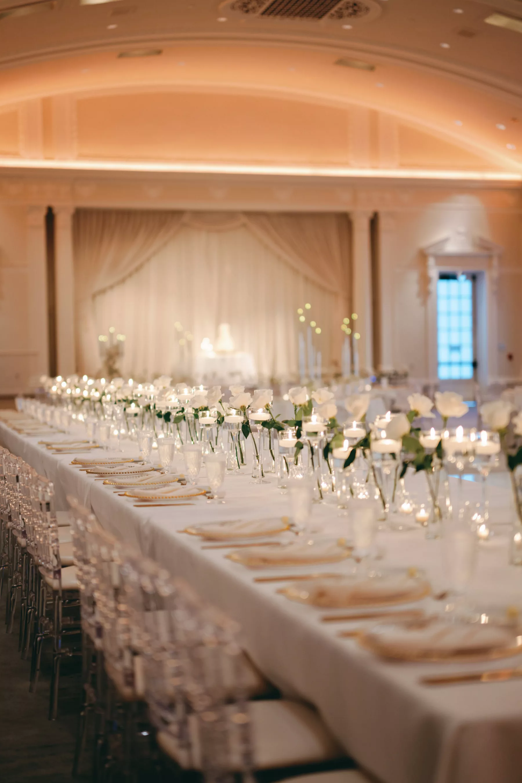 Timeless Monochromatic Wedding Reception Ideas | Romantic Centerpiece Decor Inspiration | Feasting Tables | Floating Candles, Tea Lights, and Individual White Roses in Tall Bud Vases | Tampa Bay Event Venue The Vinoy