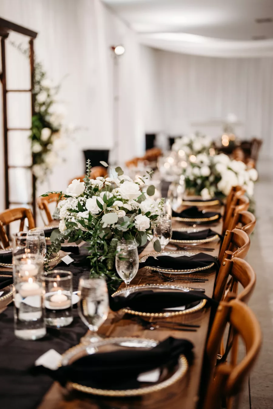 Elegant Rustic Black and White Wedding Reception Tablescape Ideas | Wooden Feasting Tables, Crossback Chairs | White Rose and Greenery Centerpiece Decor Inspiration