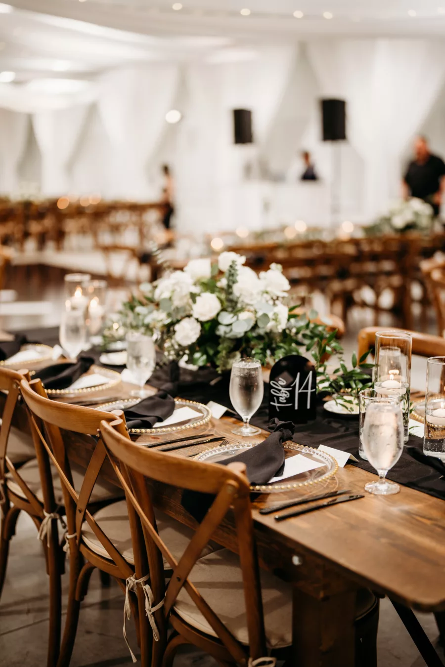 Elegant Rustic Black and White Wedding Reception Tablescape Ideas | Wooden Feasting Tables, Crossback Chairs | White Rose and Greenery Centerpiece Decor Inspiration