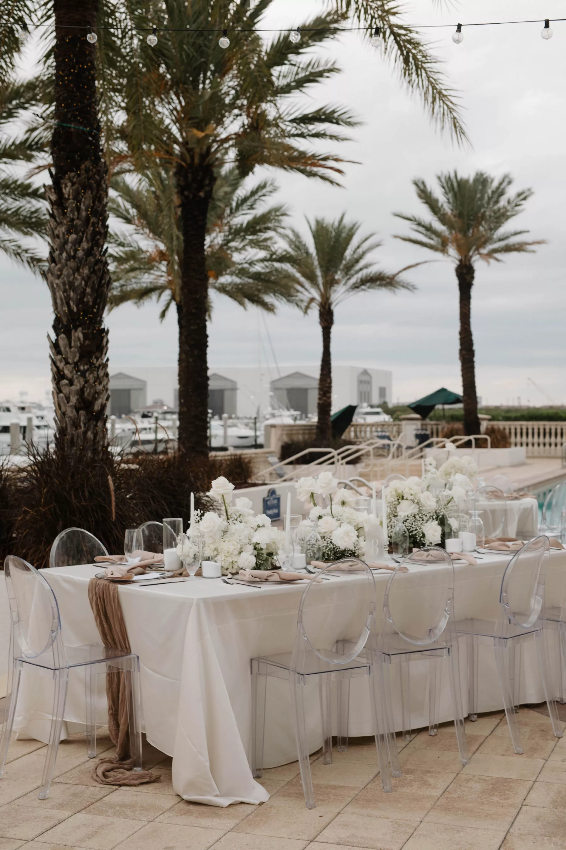 Timeless Oceanview Poolside White and Champagne Spring Wedding Reception Ideas | White Hydrangea, Orchid, and Rose Centerpiece Decor | Acrylic Ghost Chairs | Tampa Bay Kate Ryan Event Rentals | Venue Westshore Yacht Club