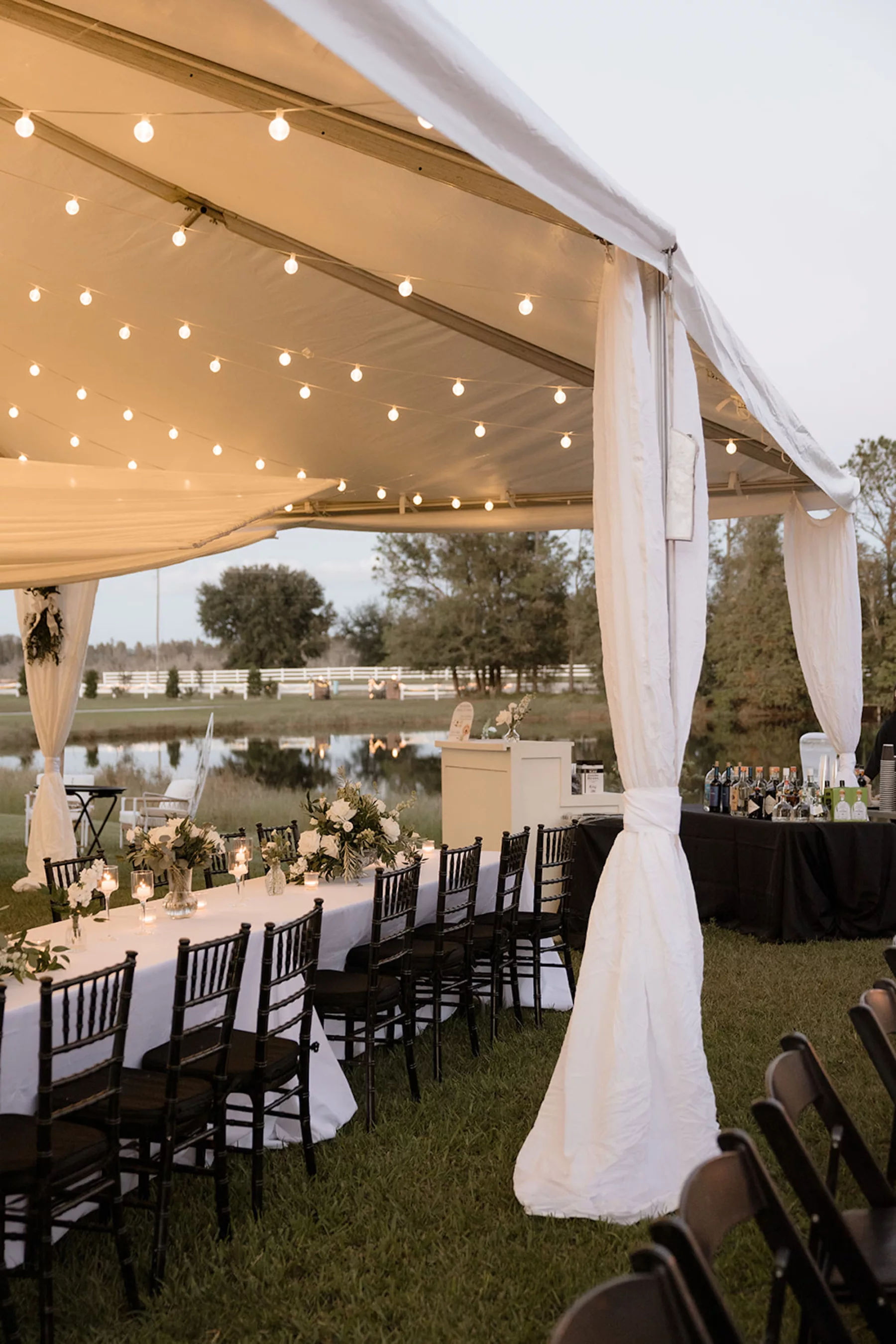 Timeless White and Black Tented Fall Wedding Reception Inspiration | Market Lights and Drapery, Long Feasting Tables and Greenery Garland Centerpiece Decor Ideas