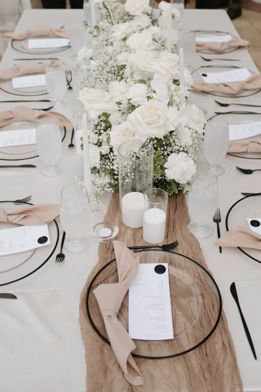 Timeless Spring Wedding Reception Tablescape Ideas | White Hydrangea, Orchid, and Rose Centerpiece Decor | Champagne Napkin Linens, Black-Rimmed Chargers, Black Flatware Place Setting Inspiration