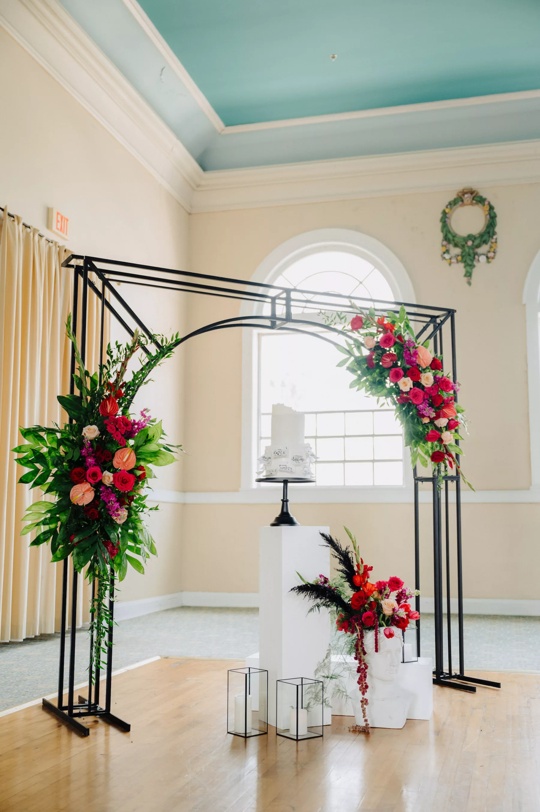 Modern Black Arbor Wedding Cake Table Display Inspiration | Bold Floral Arrangement with Pink and Red Roses, Red Anthurium, Pink Stock Flowers, and Greenery | Tampa Bay Florist Save The Date Florida