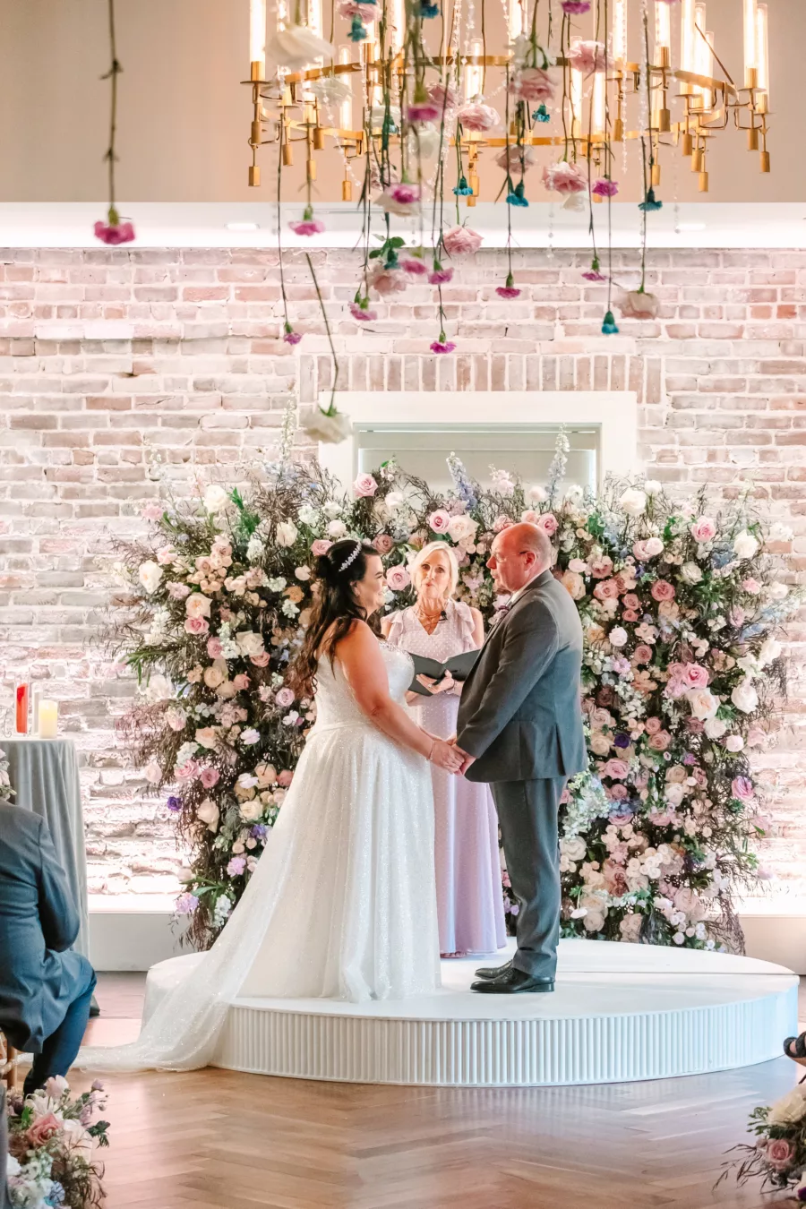 Whimsical Indoor Wedding Reception Ideas | Whimcial Pink Roses, White Hydrangeas, Blue Stock Flowers, and Greenery Backdrop Inspiration | Hanging Rose and Carnation Chandelier