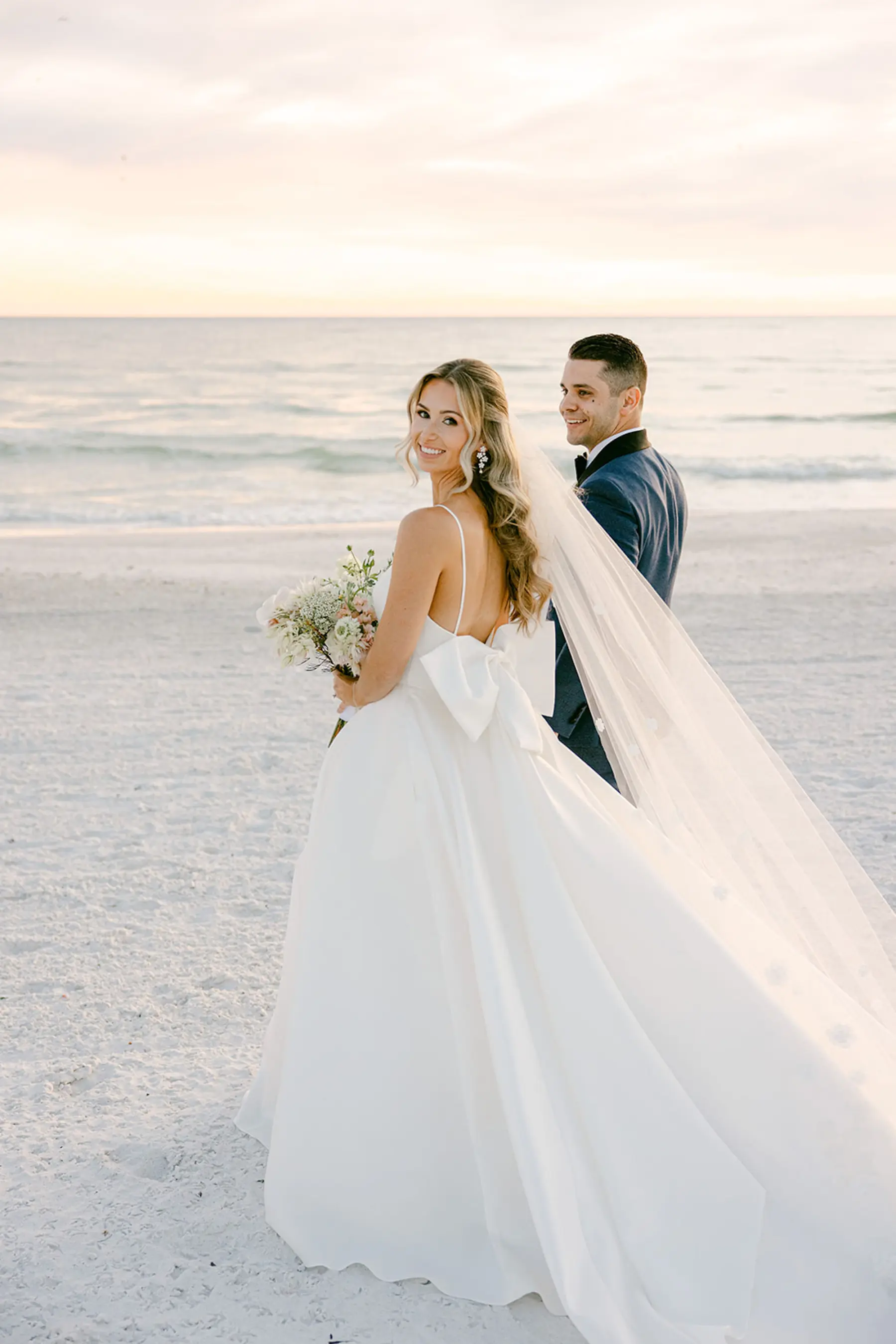 White A Line Martina Liana Beach Wedding Dress with Bow Ideas | Bridal Half Up Half Down Hair and Natural Makeup Inspiration | Sarasota Waterfront Beach Venue The Resort at Longboat Key Club | Planner Elegant Affairs by Design